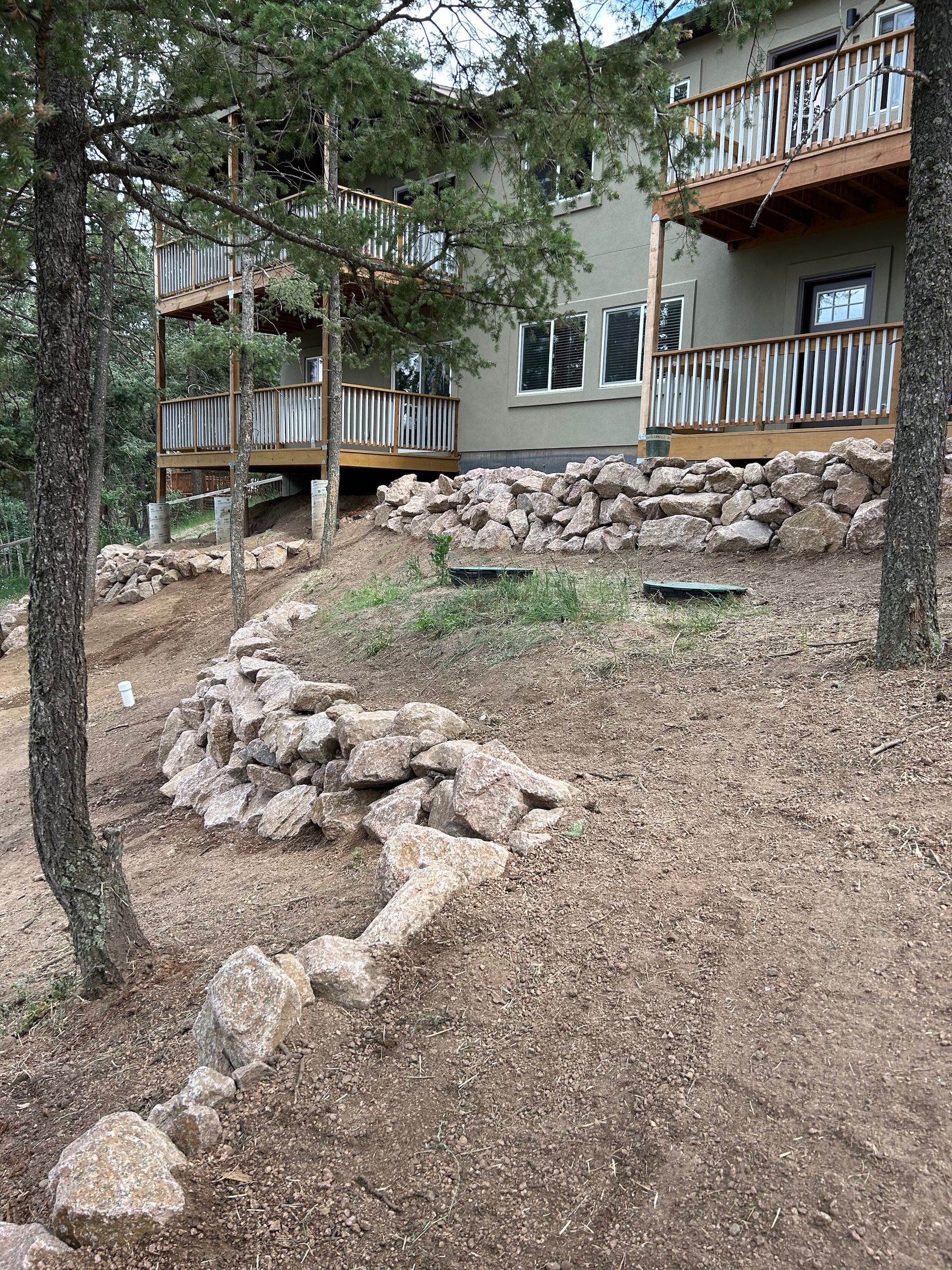 A house with a deck and a lot of rocks in front of it.