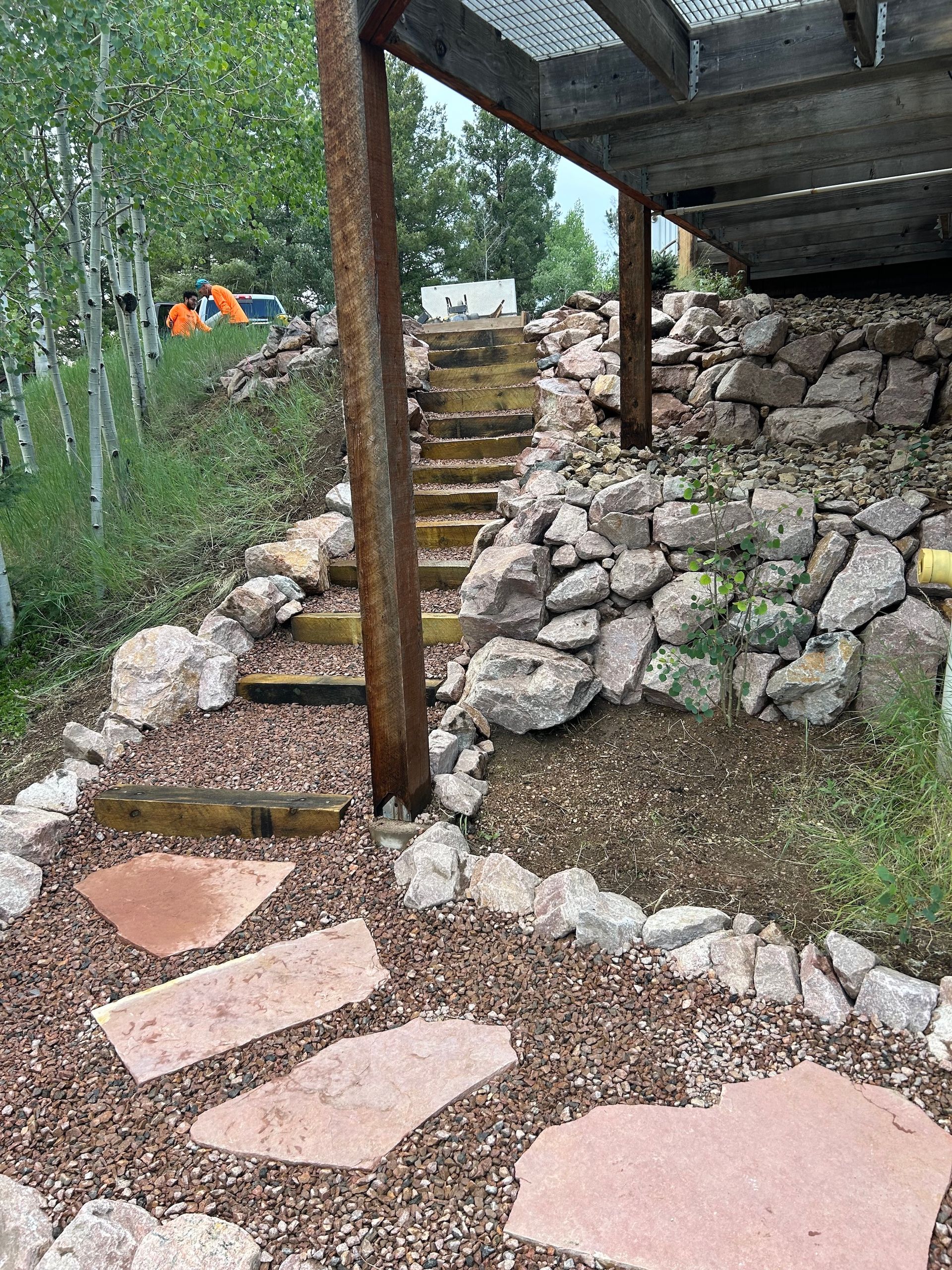 A stone walkway with stairs leading up to a wooden deck.