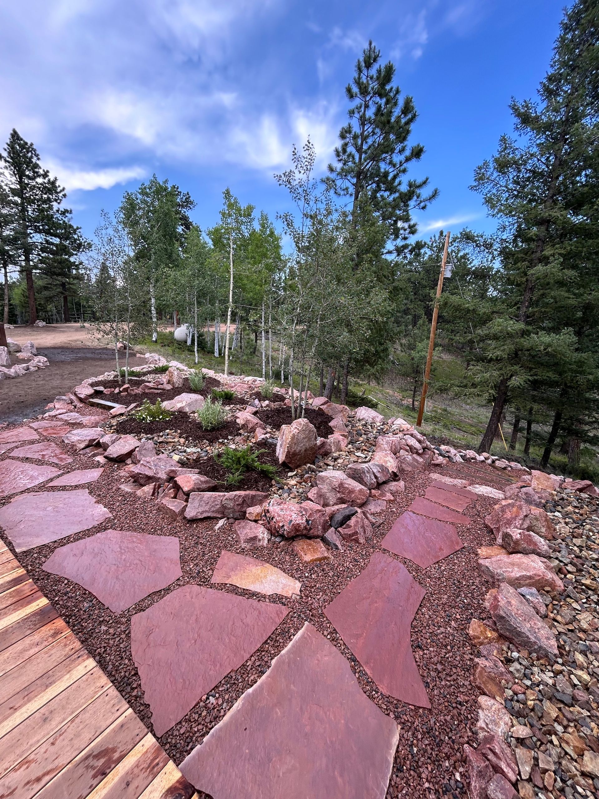 A stone walkway with trees in the background and a blue sky