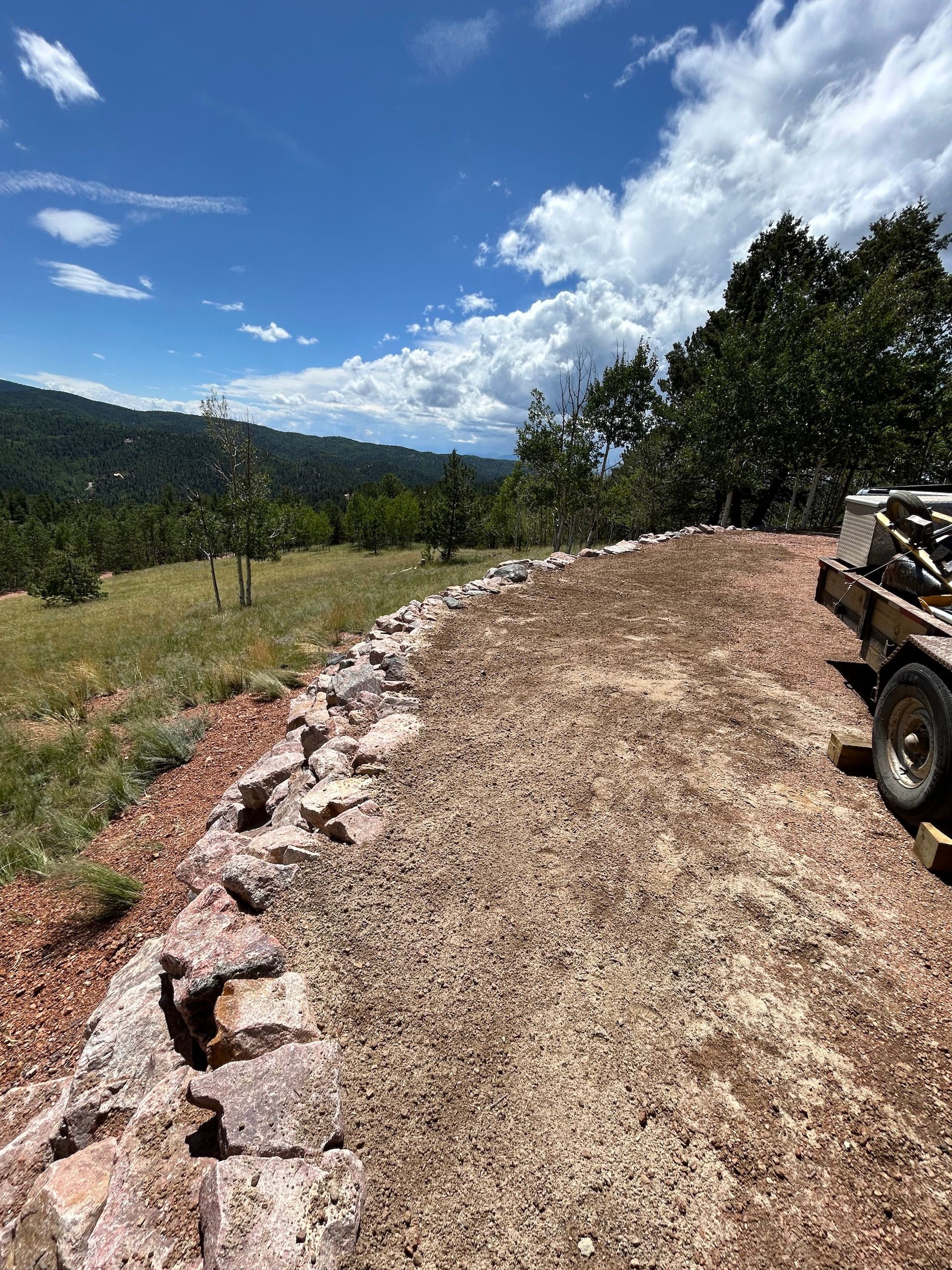 A truck is parked on the side of a dirt road.