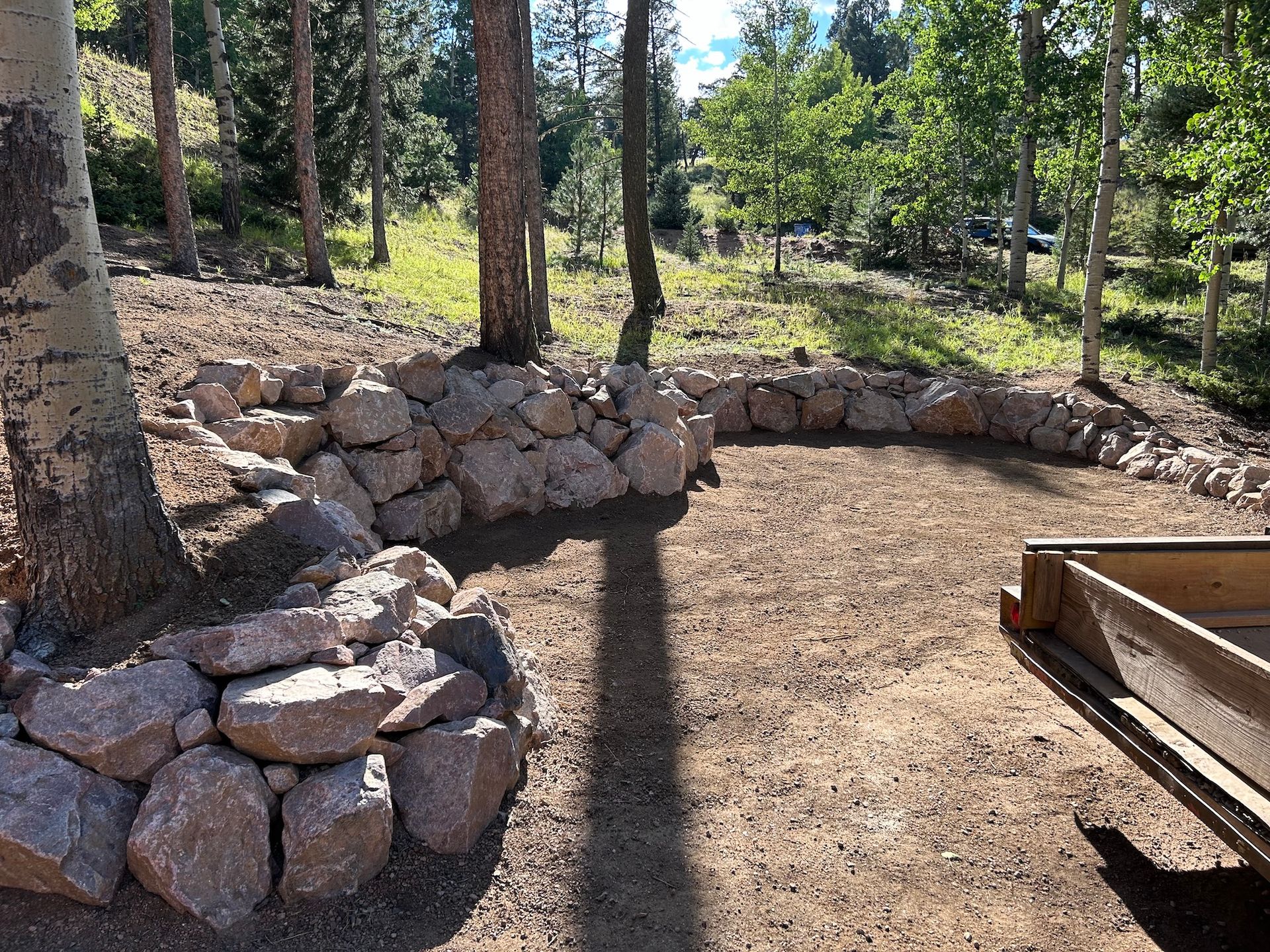 A pile of rocks is sitting in the middle of a dirt field.