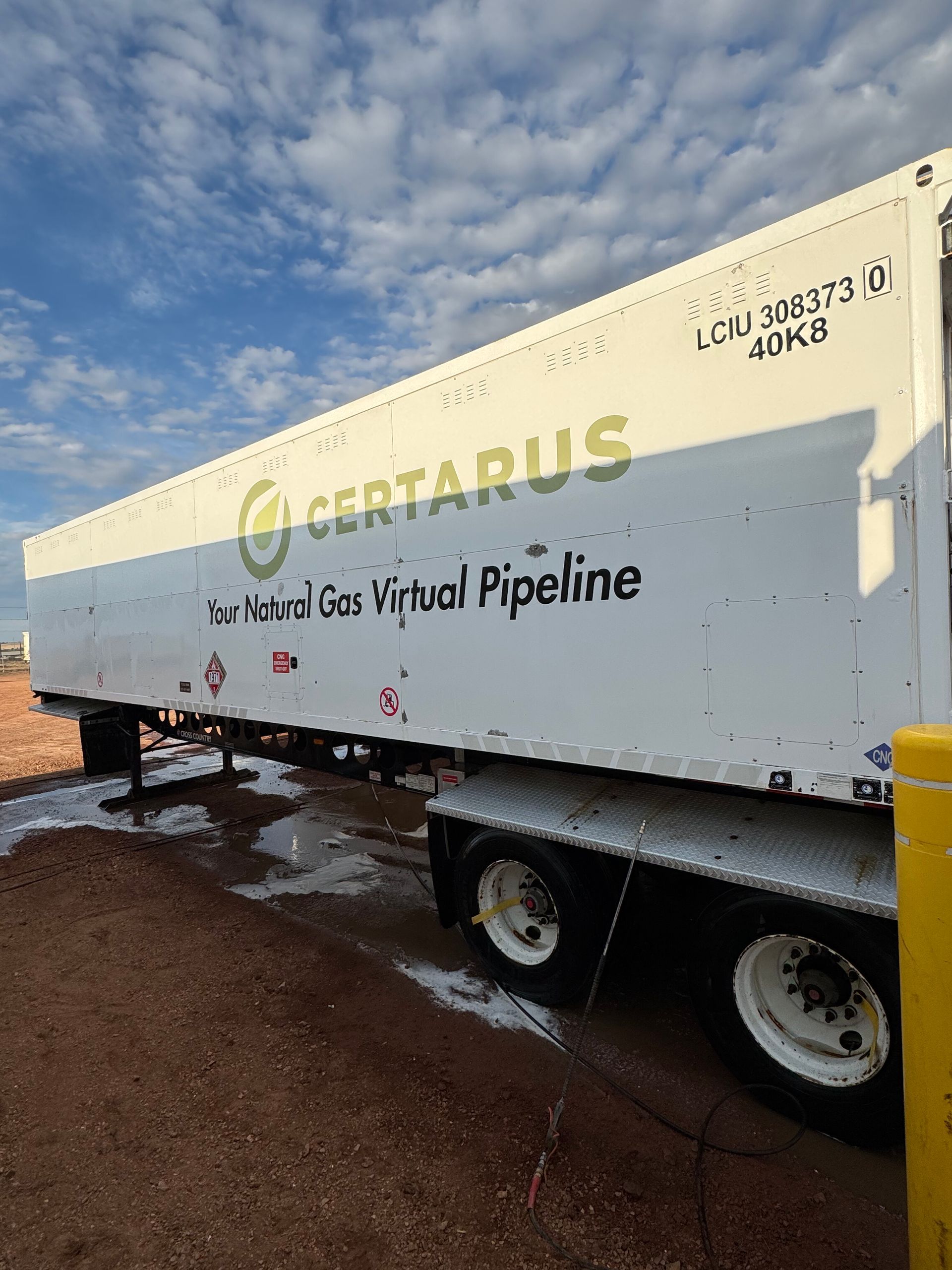White gas pipeline trailer with text “KETARUS” parked on muddy ground under a cloudy sky