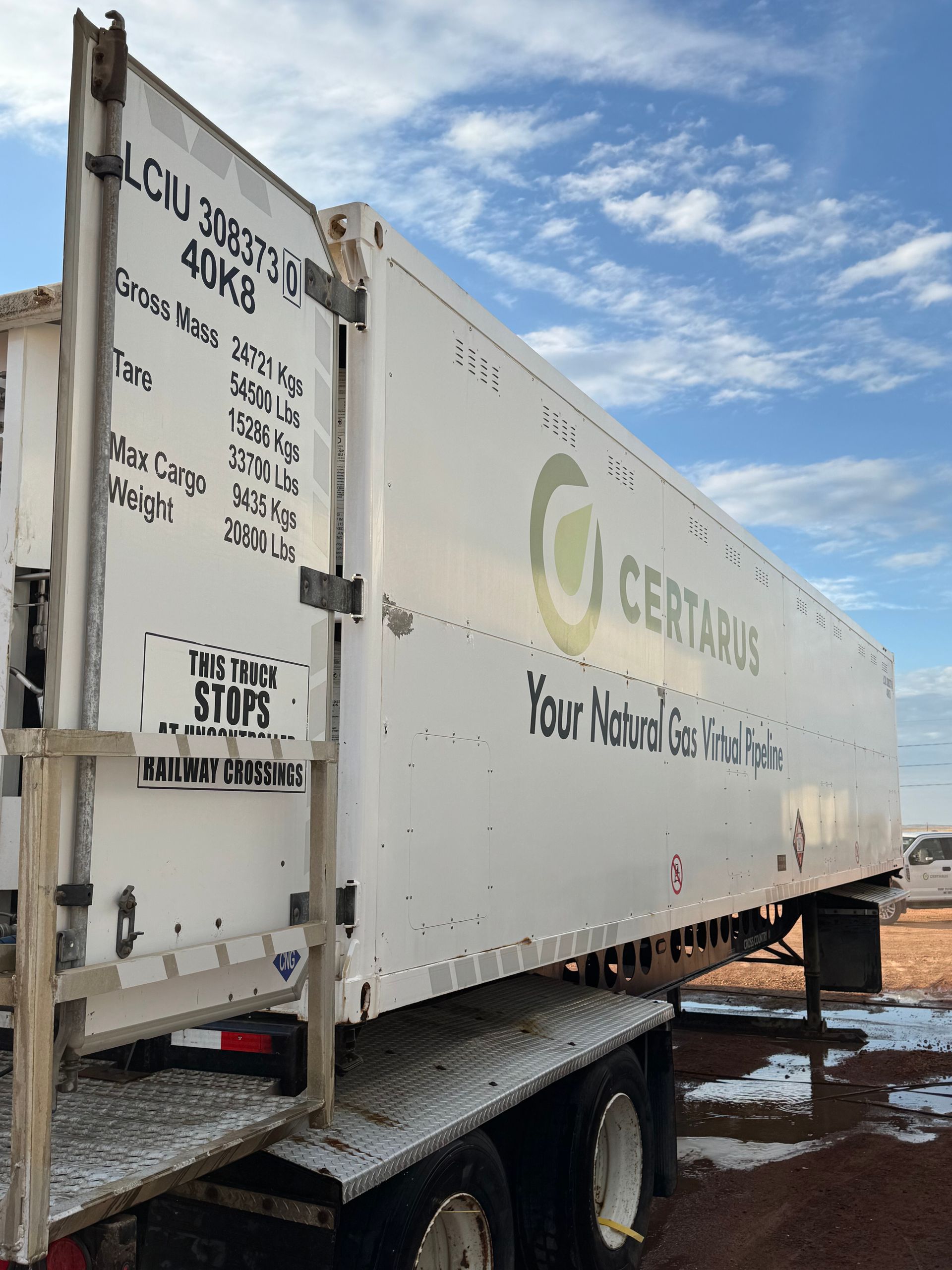 White CertiFied trailer truck parked on a snowy lot under a blue sky
