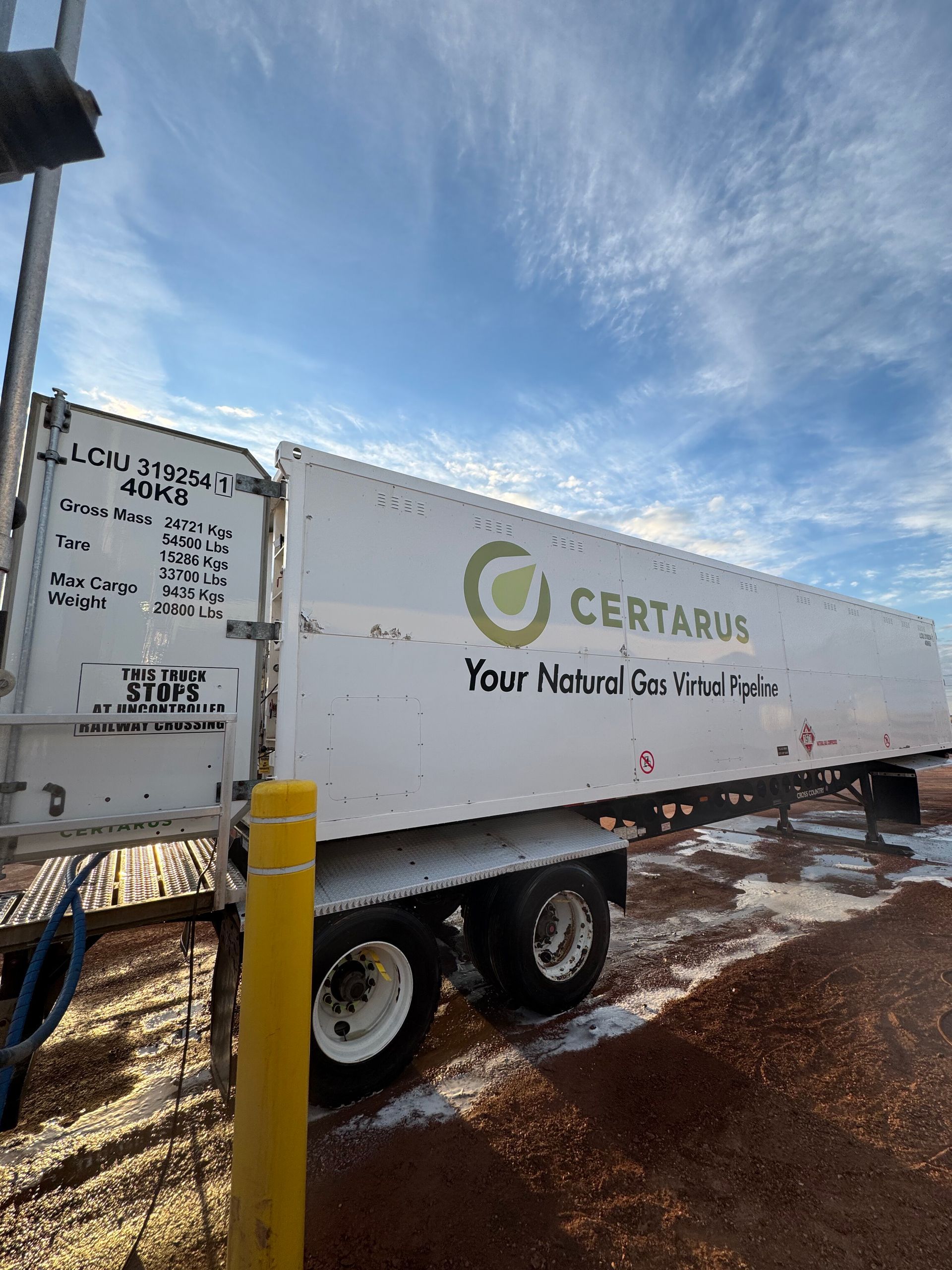 White CERTAINTY trailer truck in a snowy lot under a blue sky