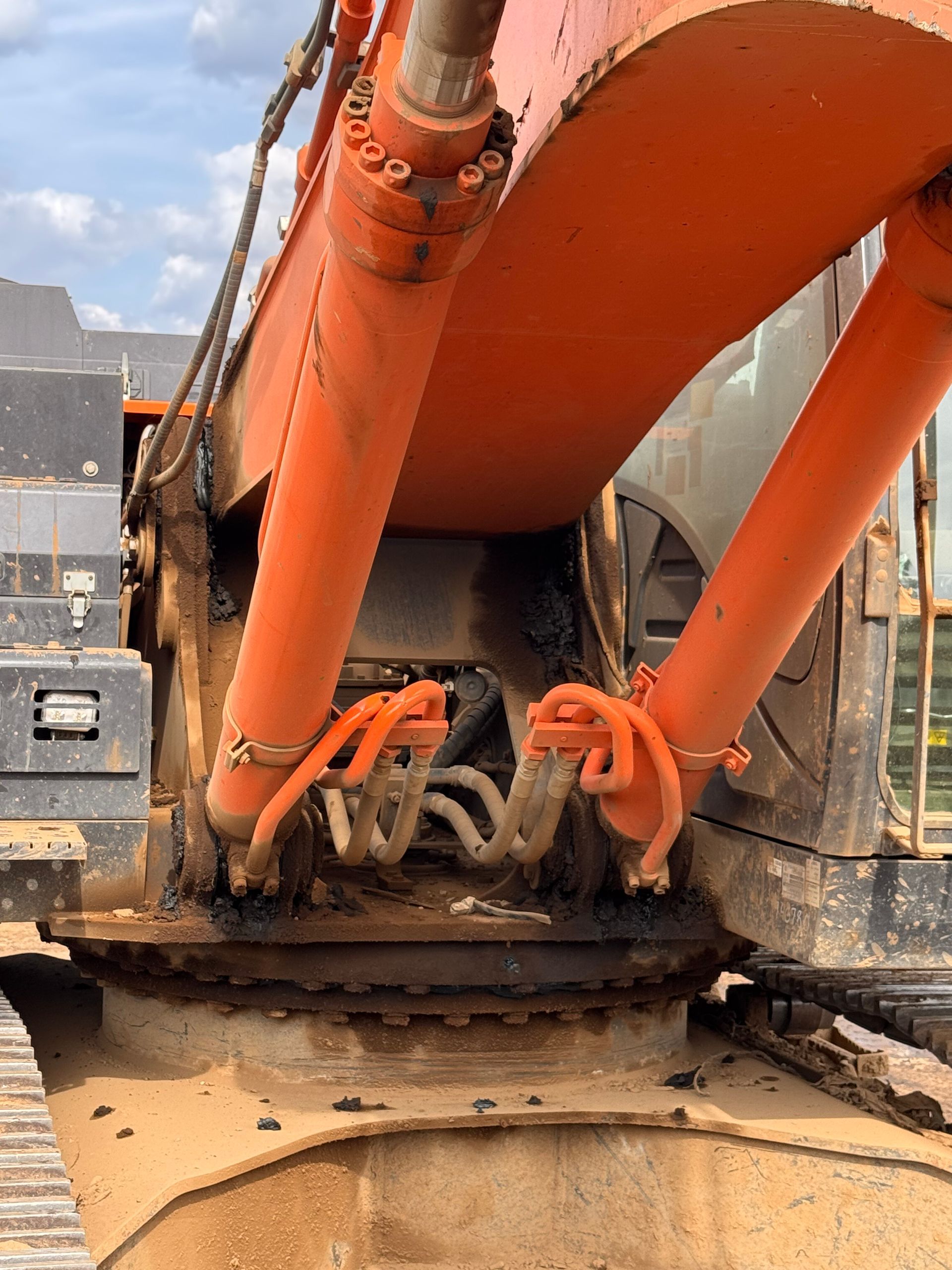 Orange excavator bucket digging into dirt at a construction site