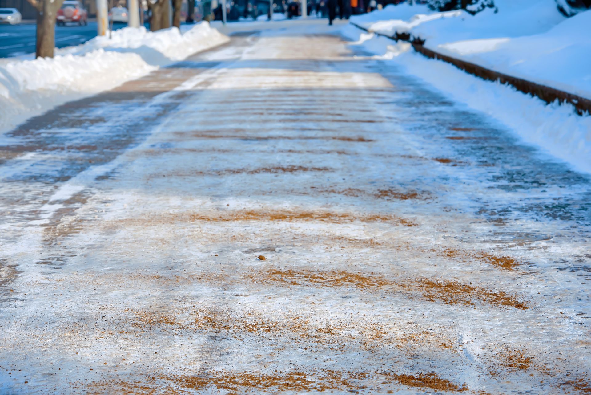 Snow-covered road with tire tracks and a clear path bordered by snowbanks in a winter scene