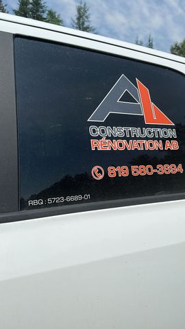 Portière de véhicule blanche avec logo autocollant noir sur la vitre et lettrage orange pour une entreprise.