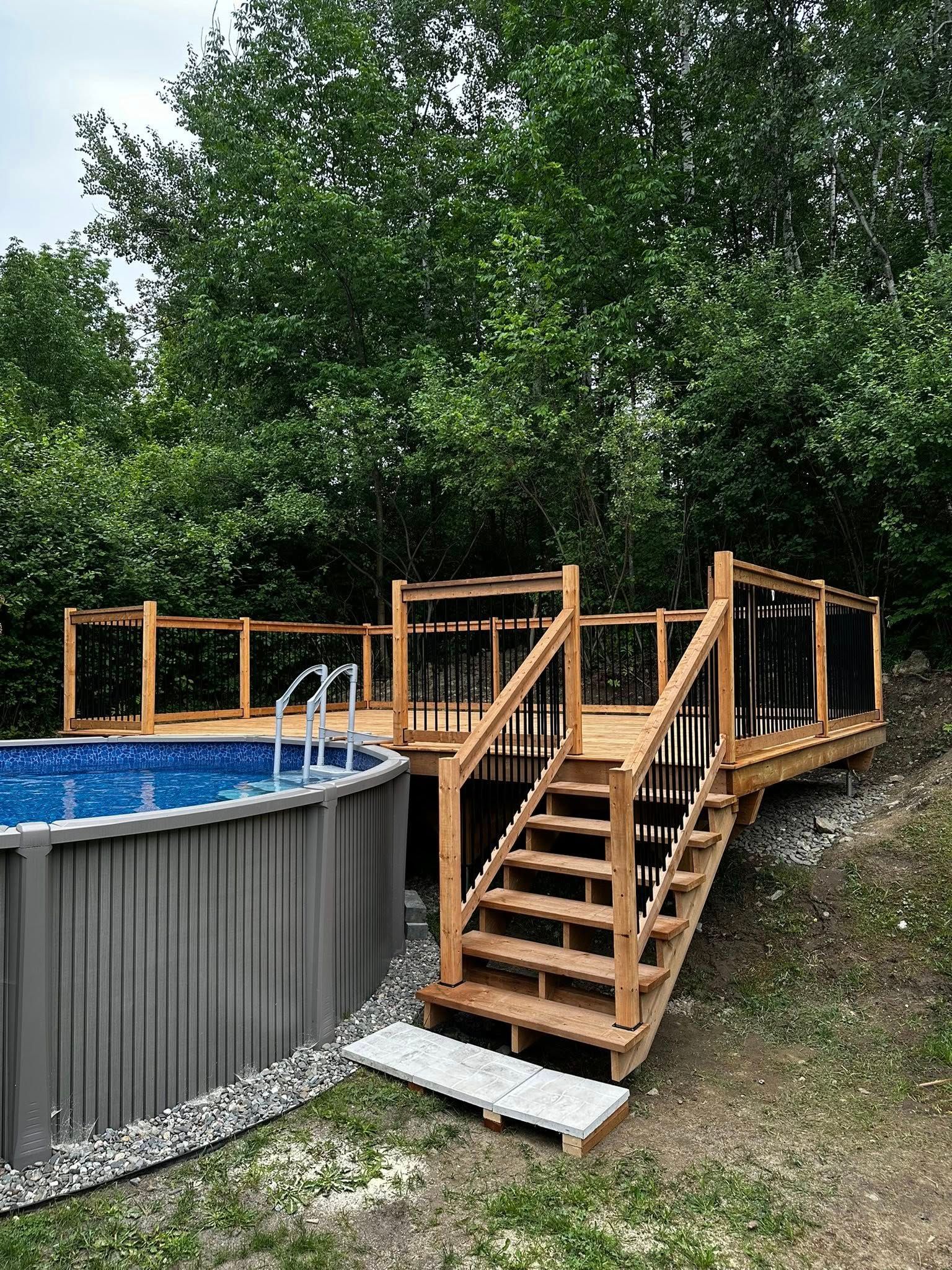 Piscine hors sol avec terrasse en bois et escalier dans une cour arrière boisée