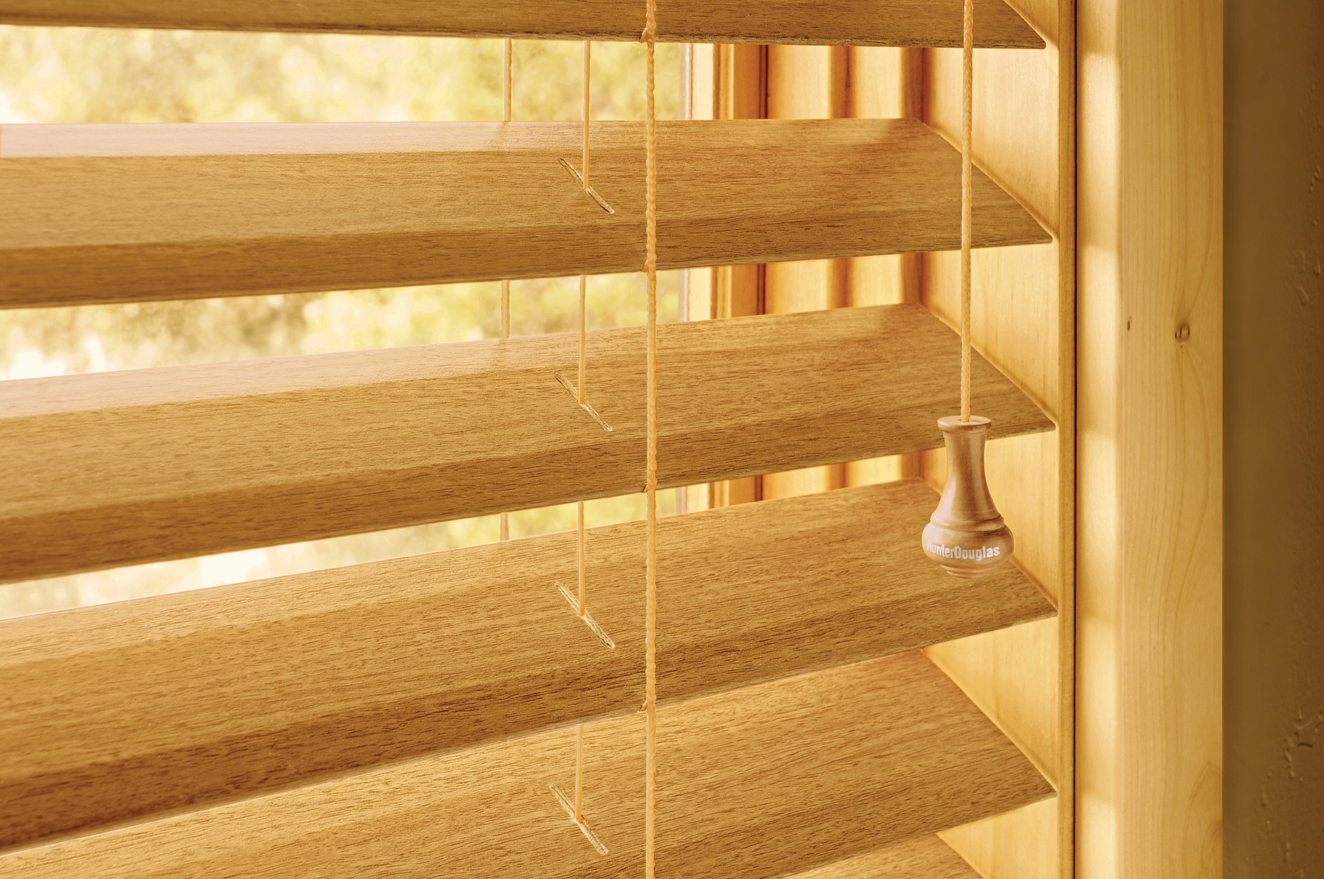 Wooden blinds filtering sunlight in a room with patterned wallpaper and a decorative chair.