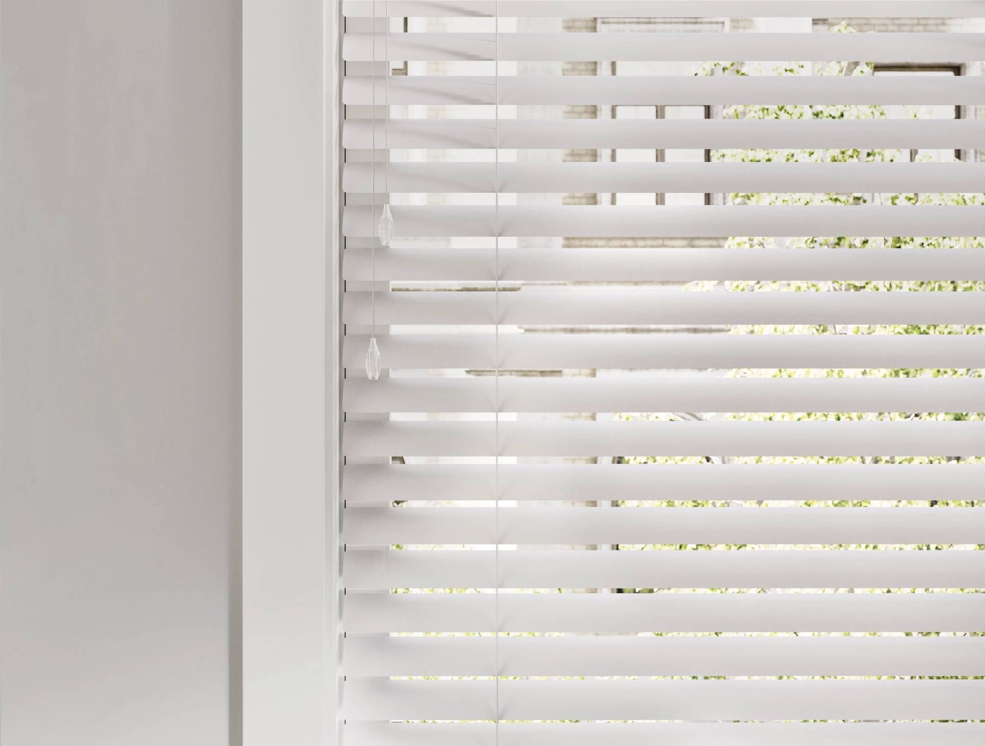 White horizontal blinds partially covering a window; the left side is a white wall.