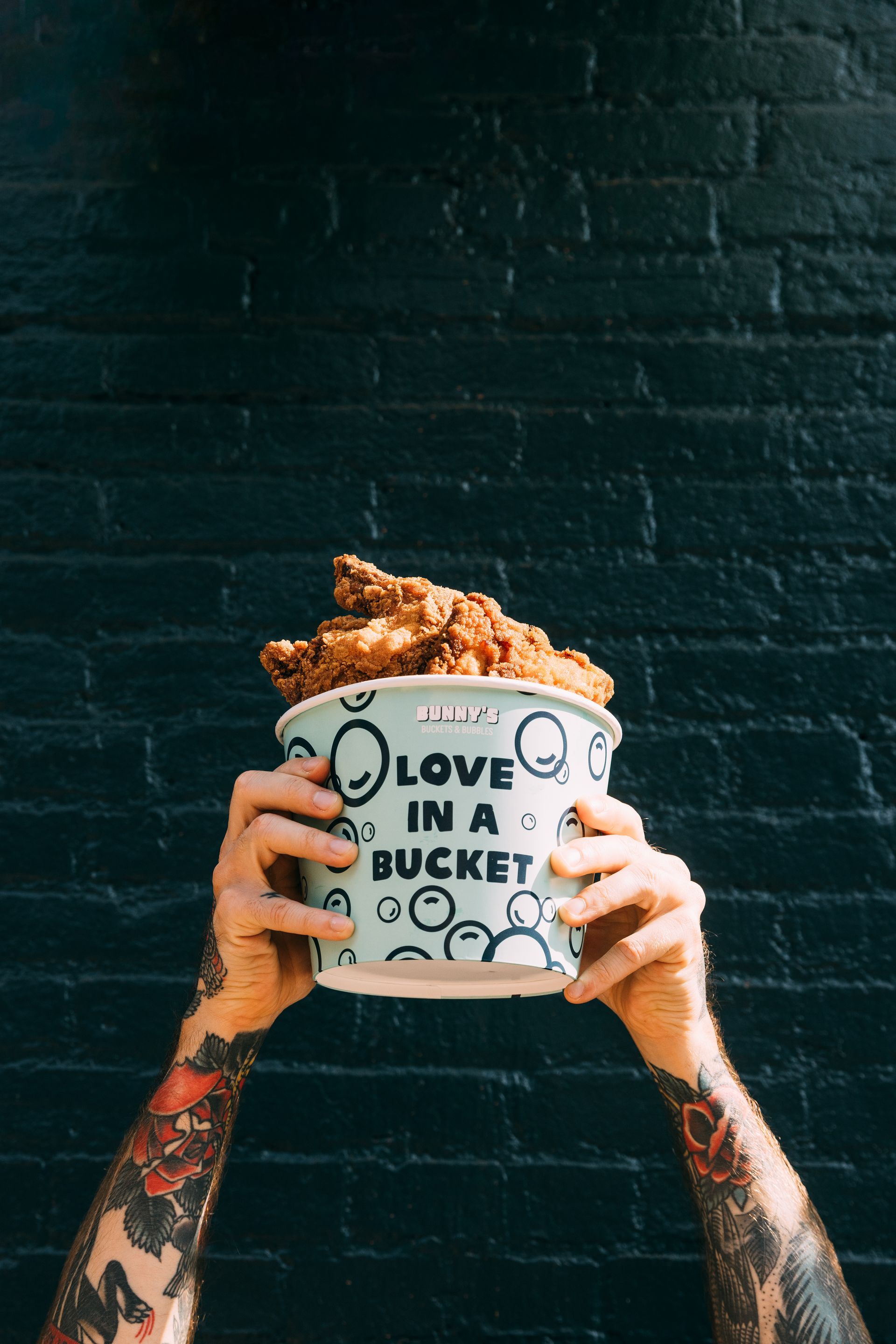 man holding a bucket of chicken