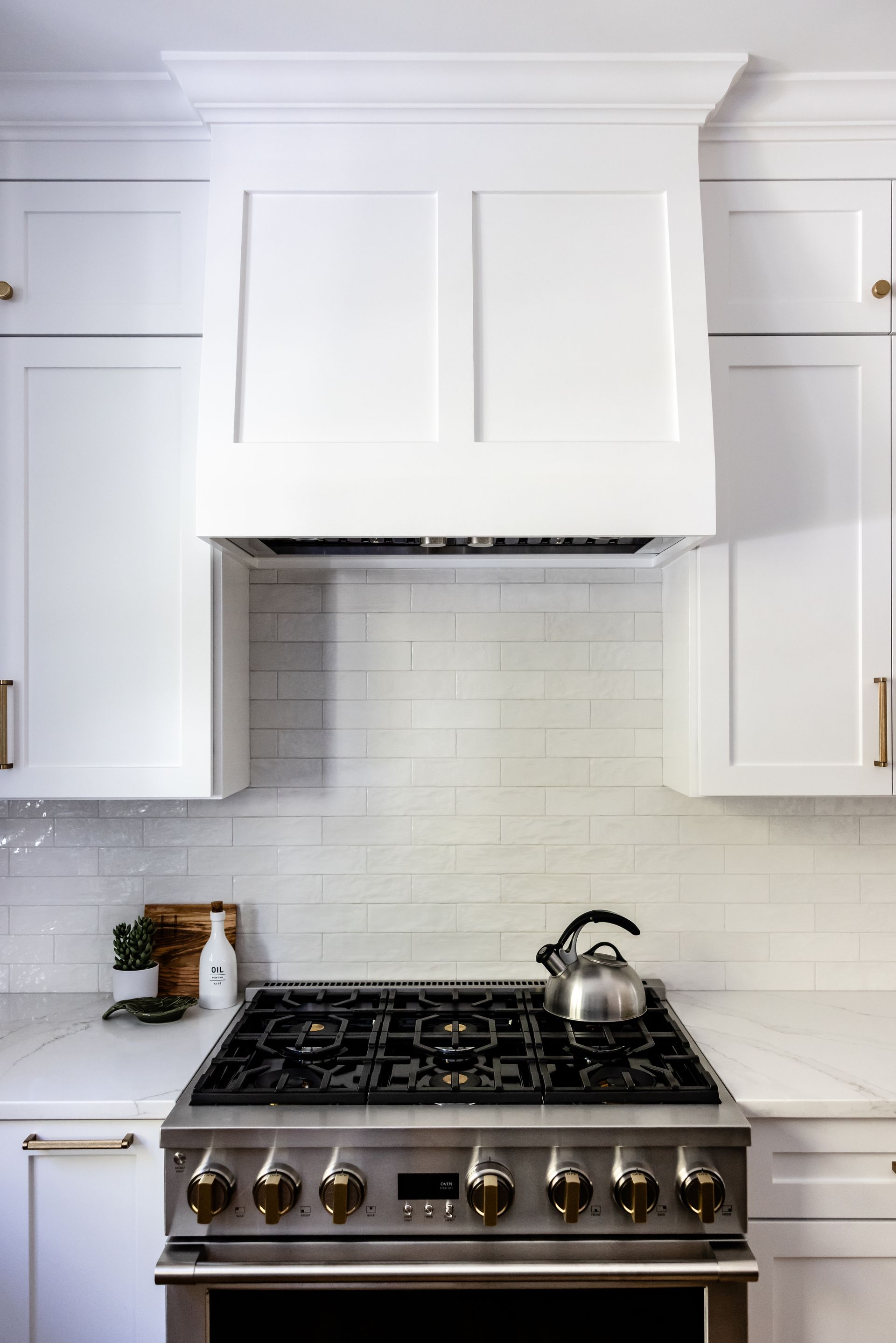 Range with white hood and handmade subway tile