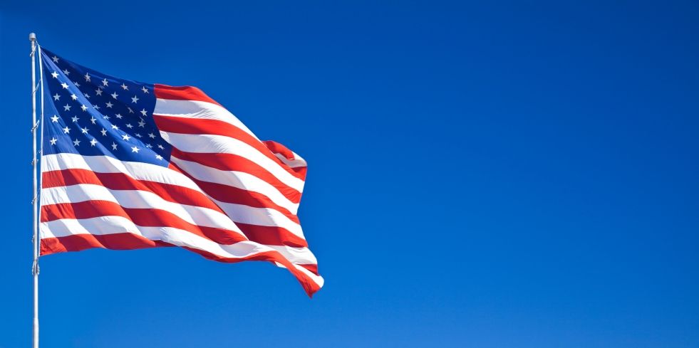 American flag waving against a clear blue sky