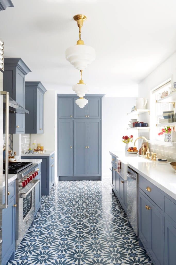 Bright blue-and-white kitchen with patterned tile floor and gold pendant lights