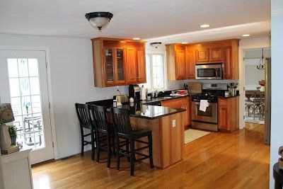 Bright kitchen and dining area with wood cabinets, island seating, and hardwood floors