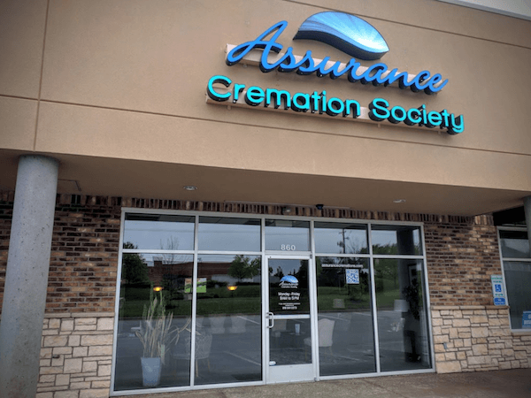 Entrance to Assurro Cremation Society storefront with glass doors and blue sign