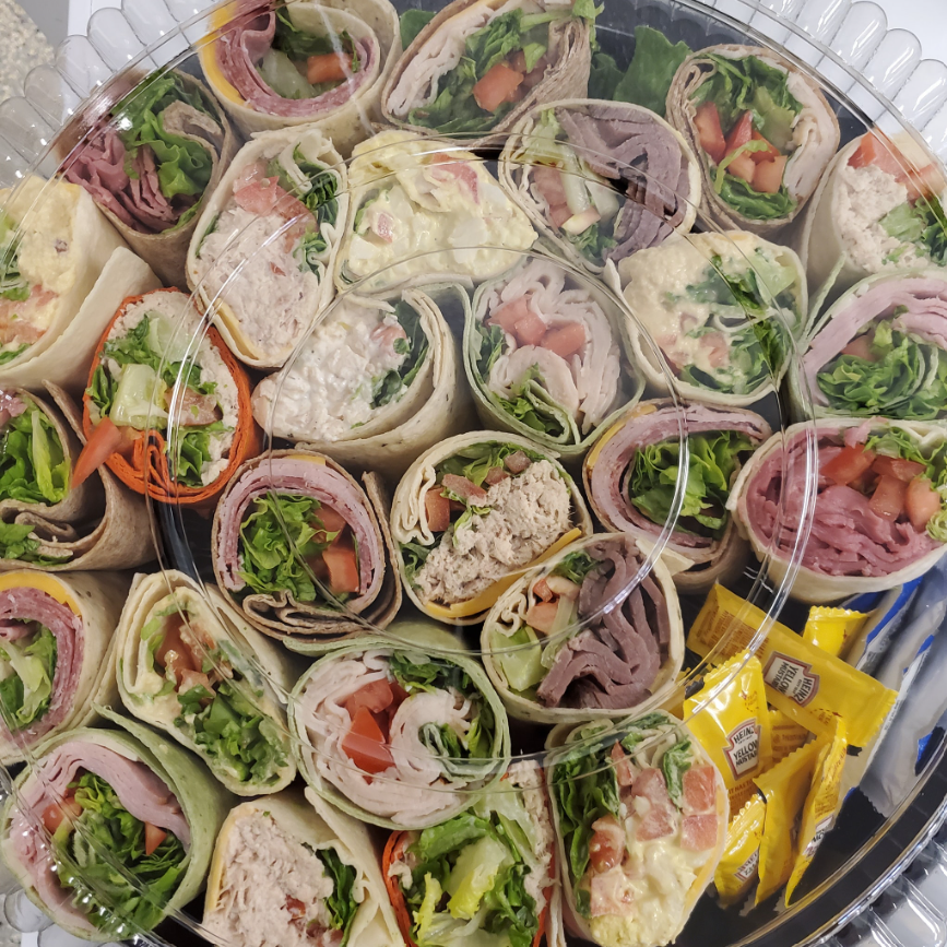 Catering Menu - Pasta dish with lettuce, meat, and cheese, served with garlic bread.