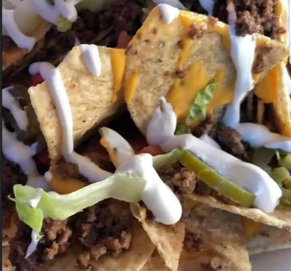 Nachos with ground meat, cheese, sour cream, and jalapeños.