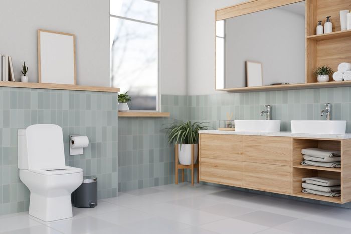 A bathroom with a toilet , sink and mirror.