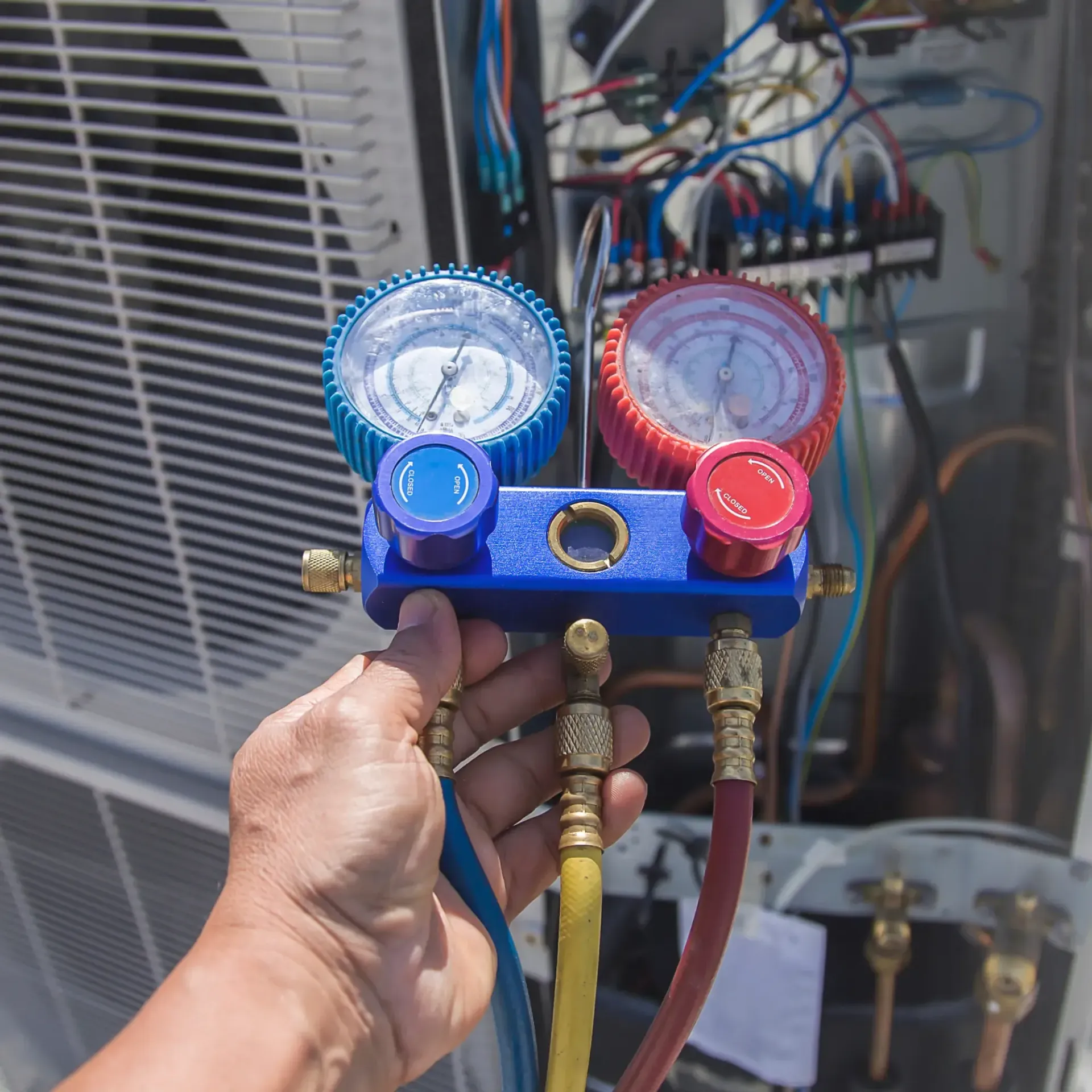 Aarden Air Service Heating & Air Conditioning - A person is holding a blue and red gauge in their hand