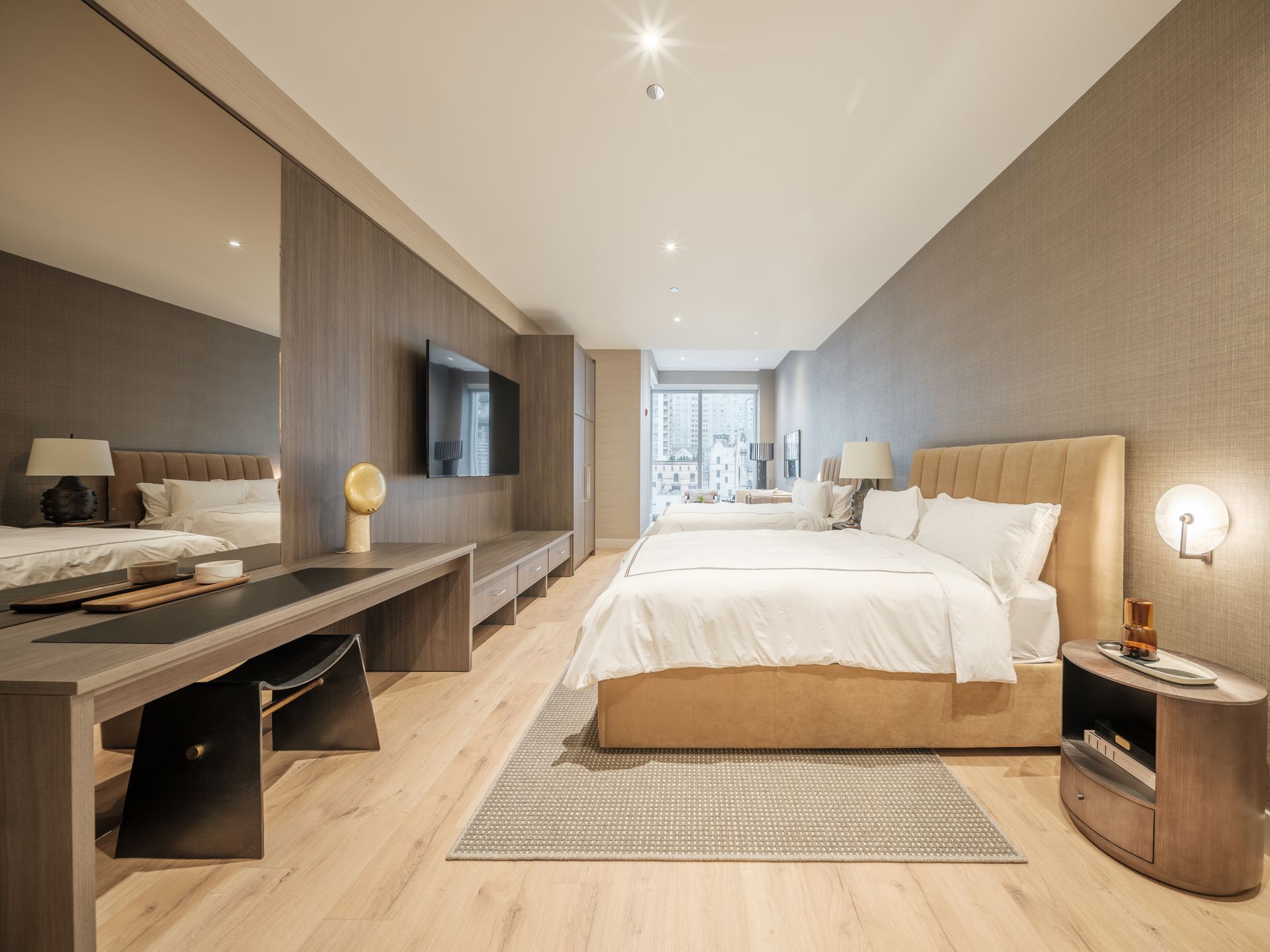 A hotel room with two beds , a desk and a television.