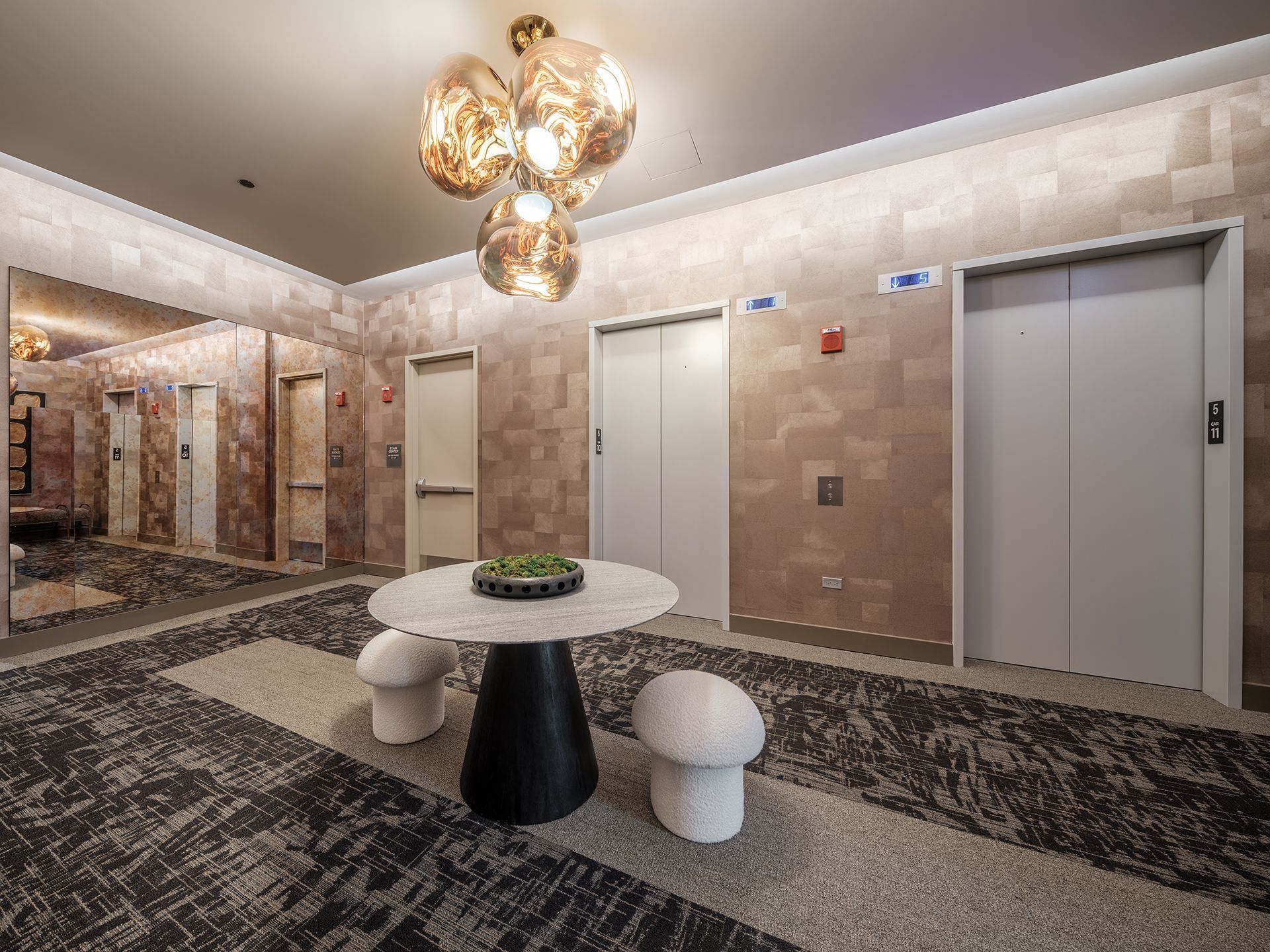 A hallway with elevators and a table with mushrooms on it.
