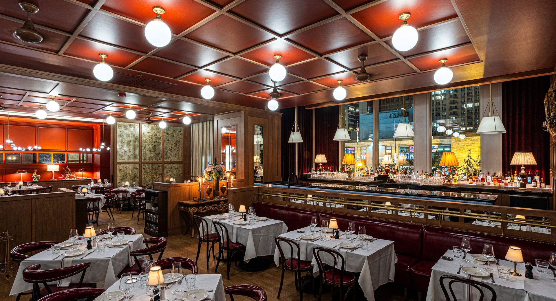 A large dining room with tables and chairs and a red ceiling.
