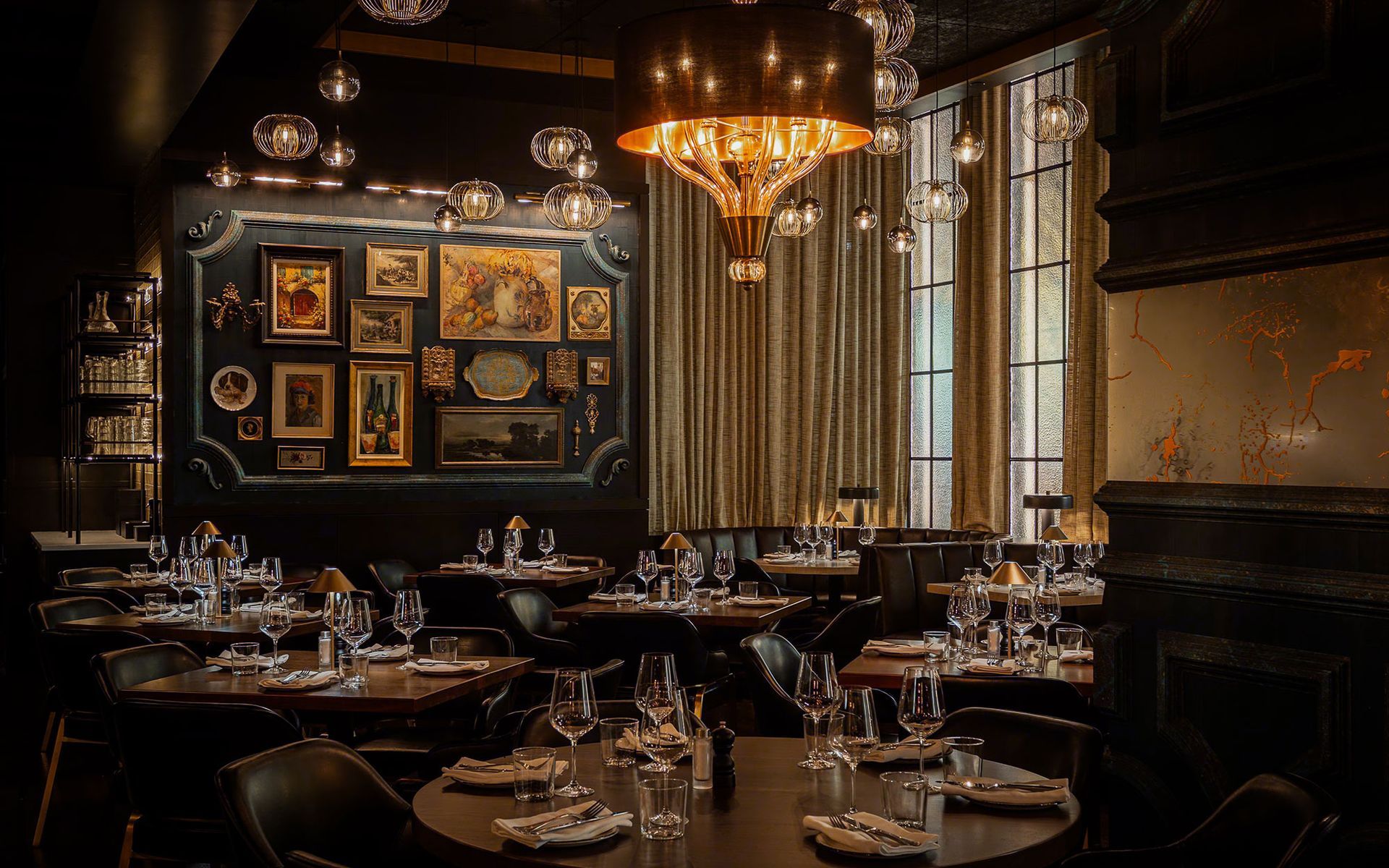 A restaurant with a lot of tables and chairs and a chandelier hanging from the ceiling.
