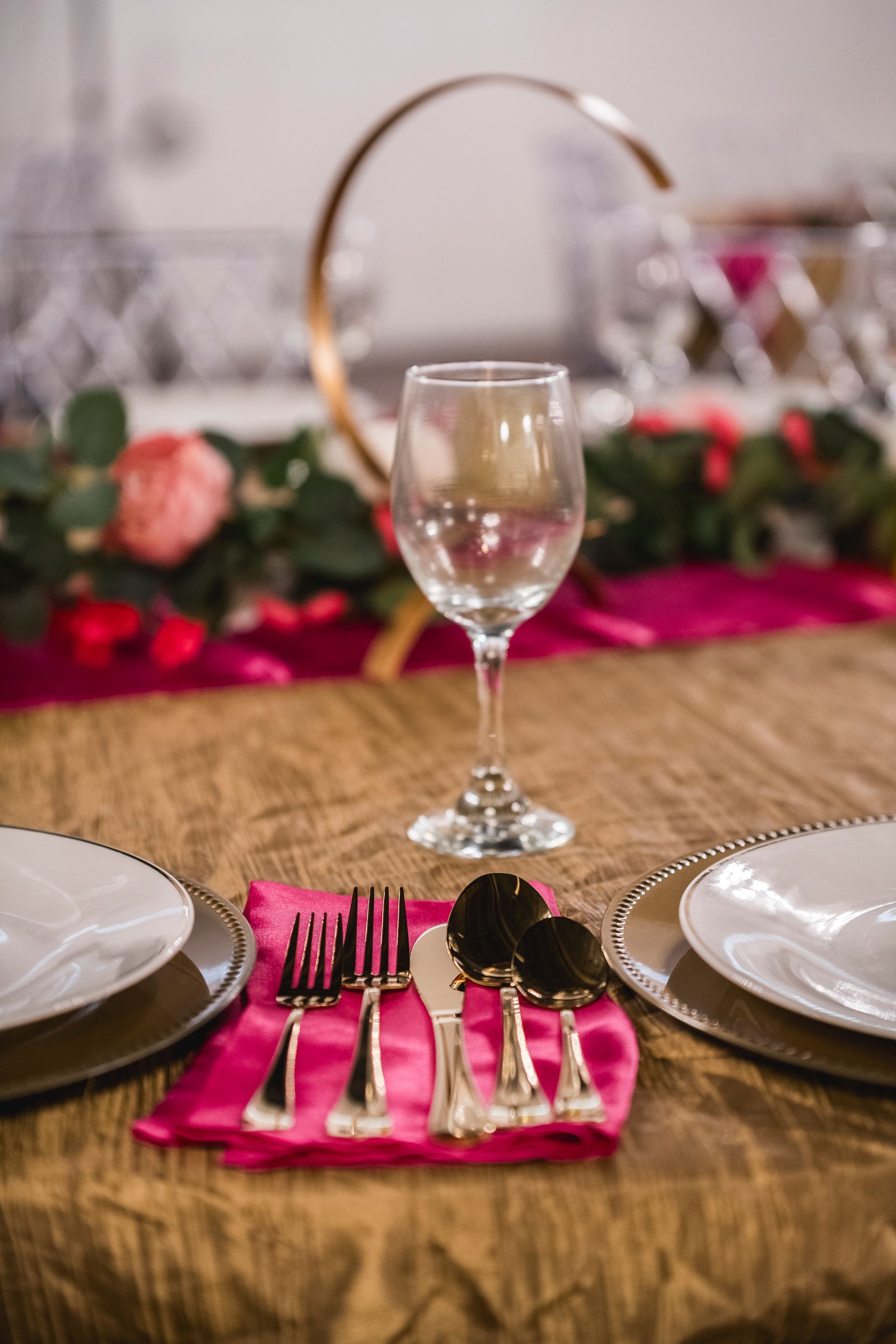 Elegant table setting with pink napkins, silverware, and wine glasses for a formal dinner