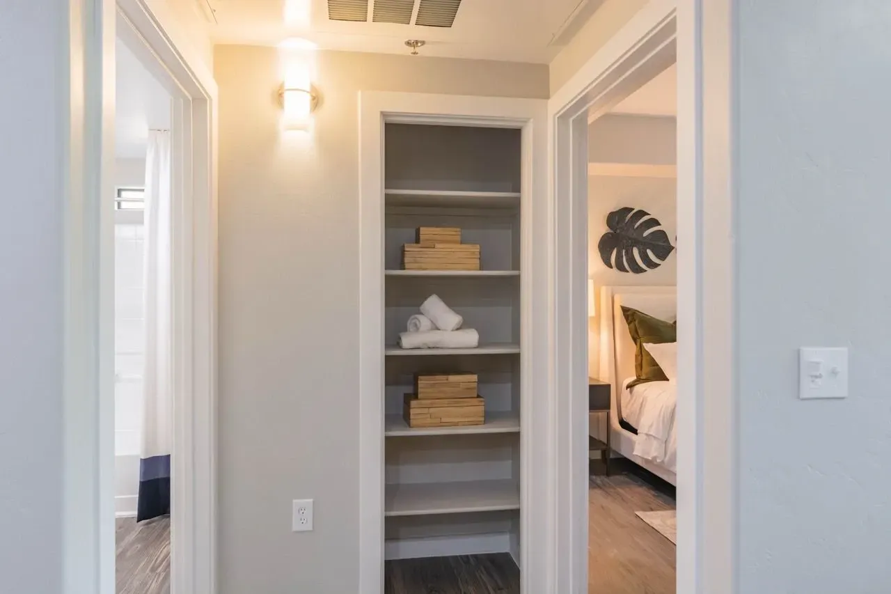 Hallway with linen closet and doorway to bedroom