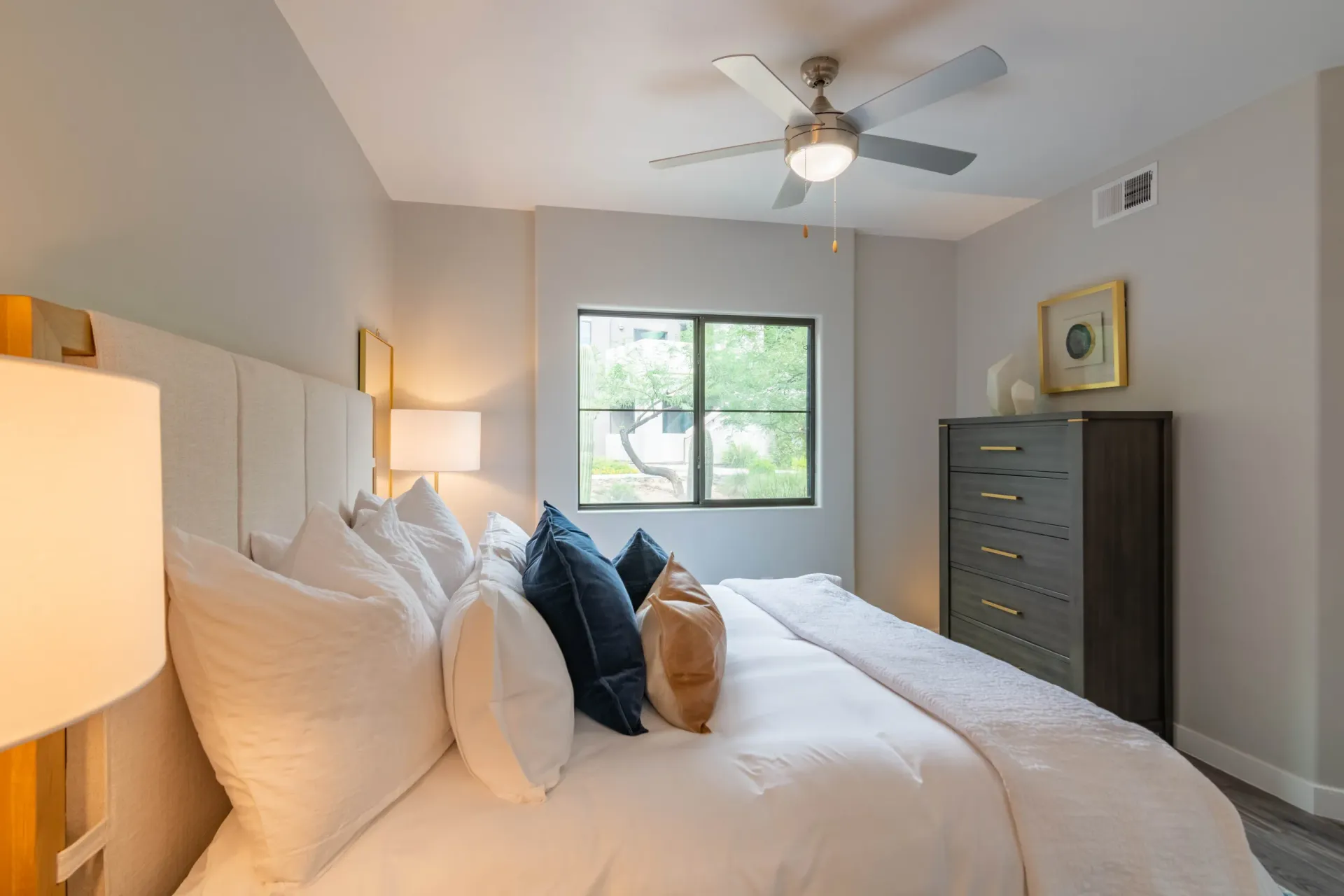 Bedroom with a king-size bed, nightstands, a dresser, and a ceiling fan.