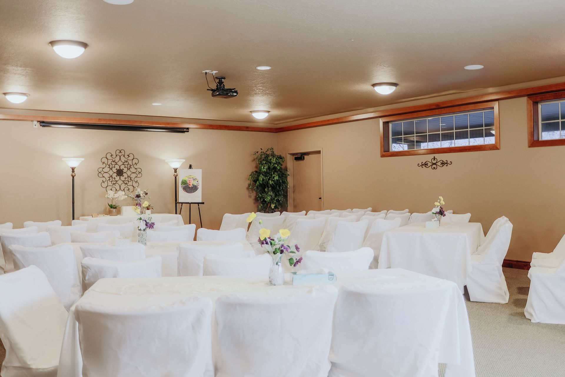 Empty banquet hall with round tables draped in white linens and soft ceiling lights
