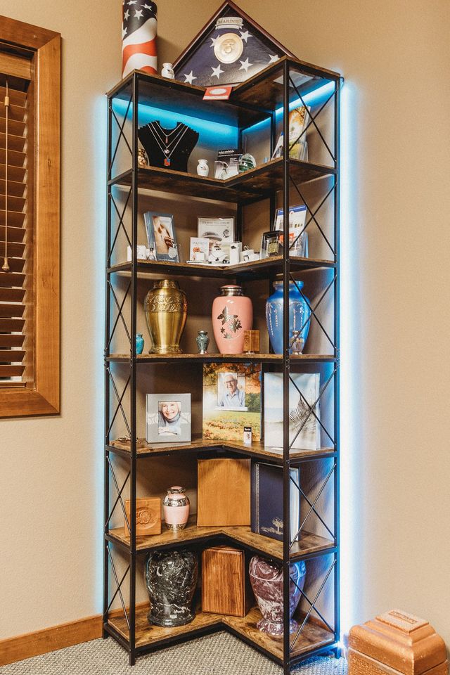 Lit black display shelf with blue LED lights, holding books and decor in a warm room.