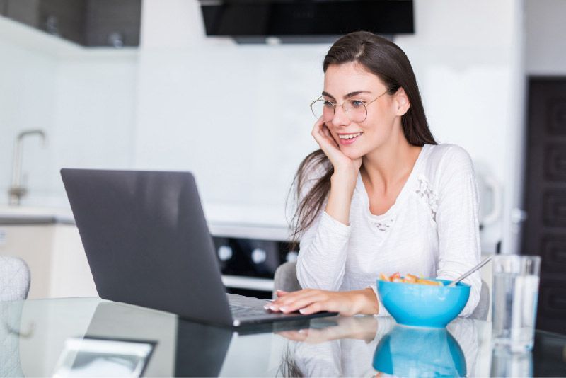 Woman looking at laptop on kitchen island