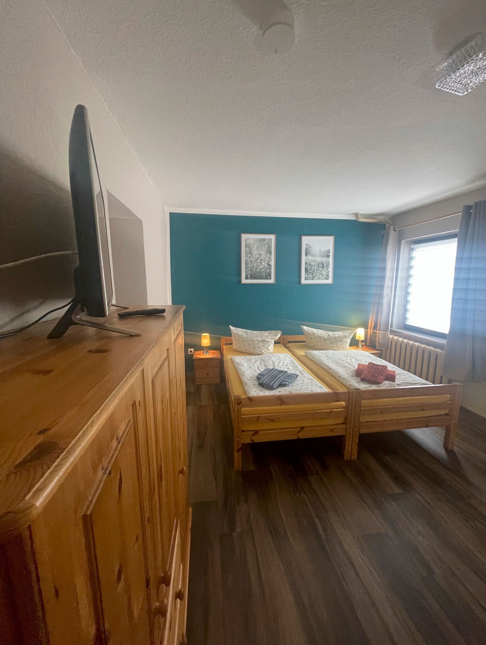 Ein Schlafzimmer mit zwei Betten und einem Flachbildfernseher.