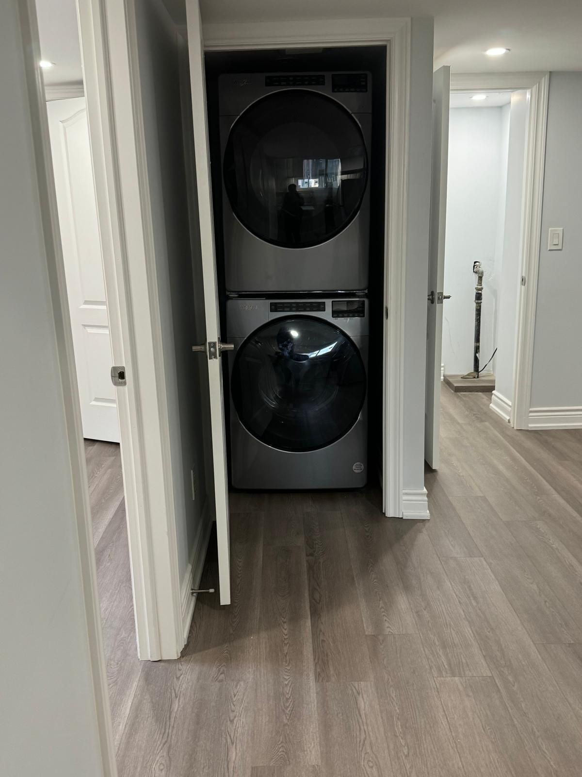 A washer and dryer are stacked on top of each other in a closet.