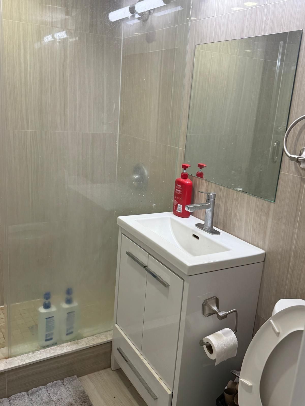 A bathroom with a sink , toilet and shower.