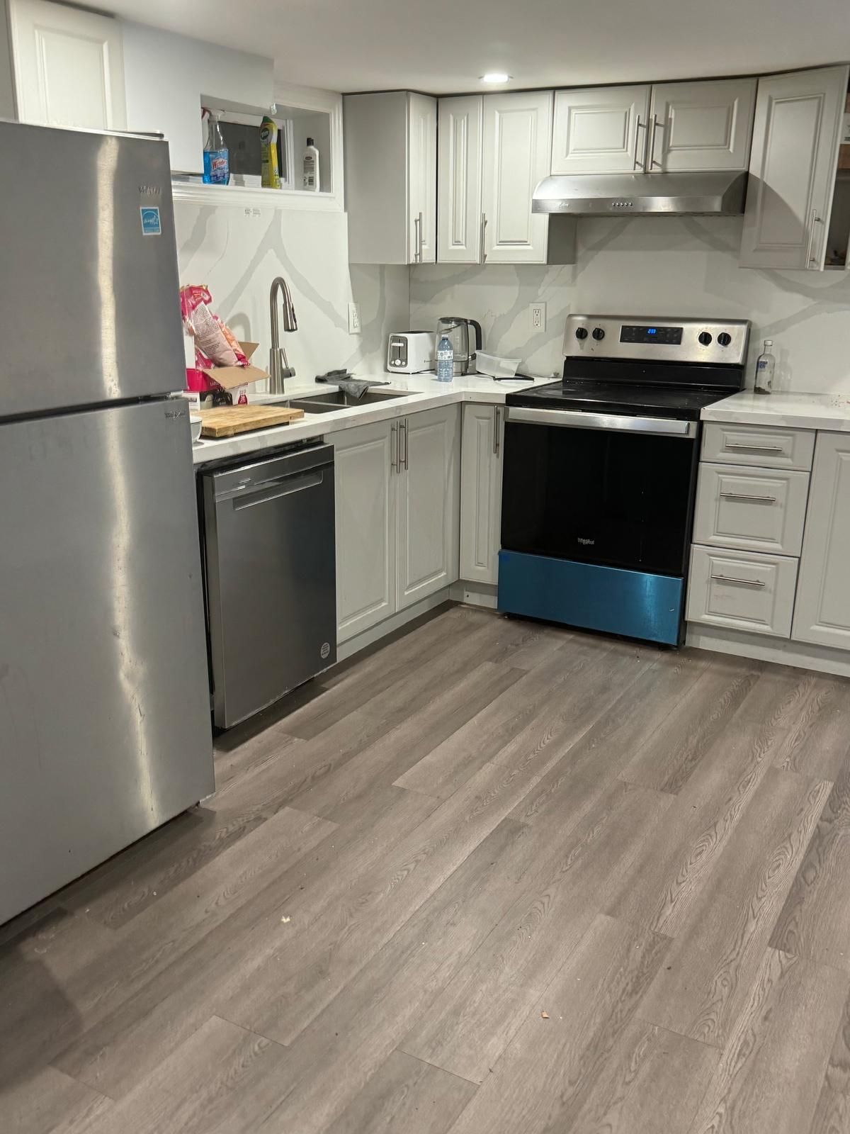 A kitchen with stainless steel appliances and white cabinets