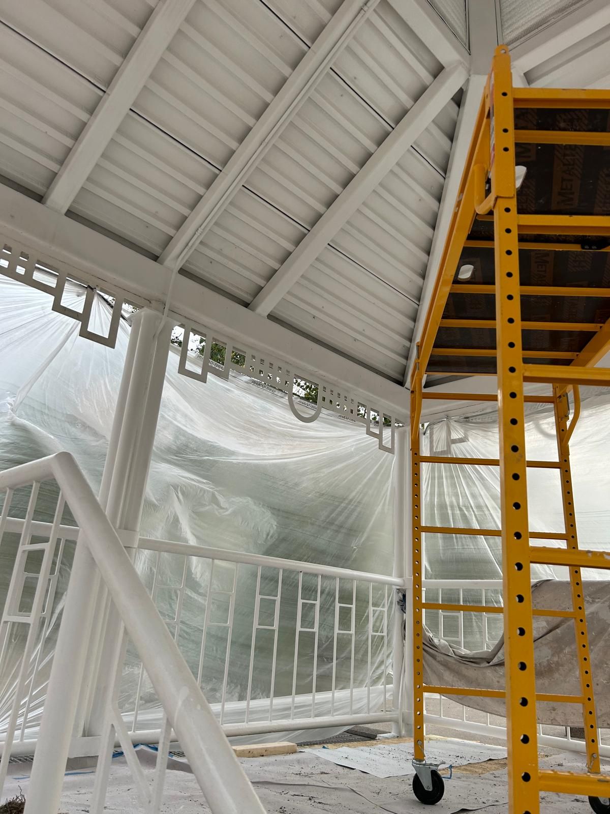 A yellow scaffolding is sitting under a white roof.