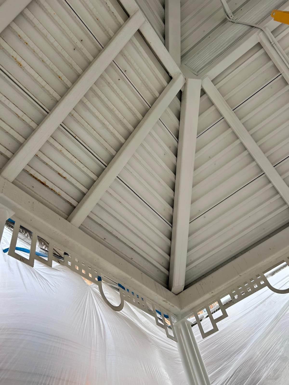 Looking up at the ceiling of a gazebo with a ceiling fan
