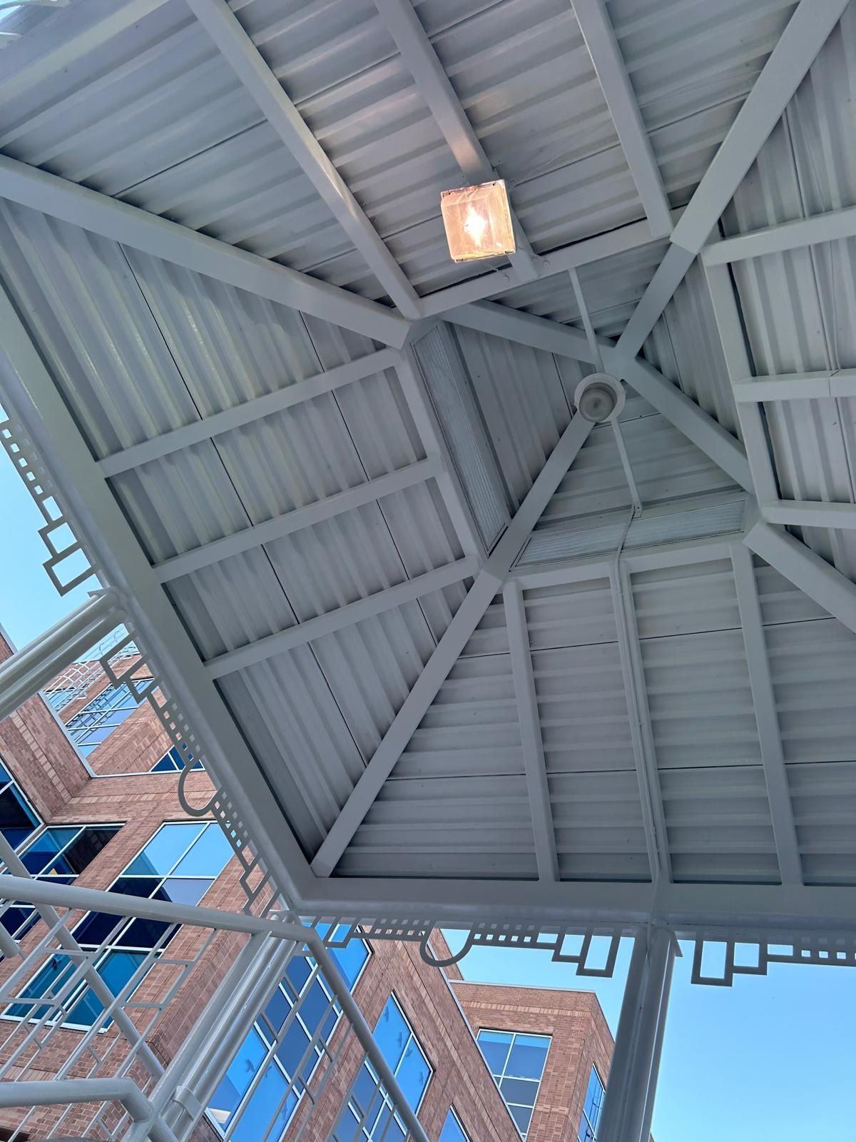 Looking up at the ceiling of a building with a light hanging from it.