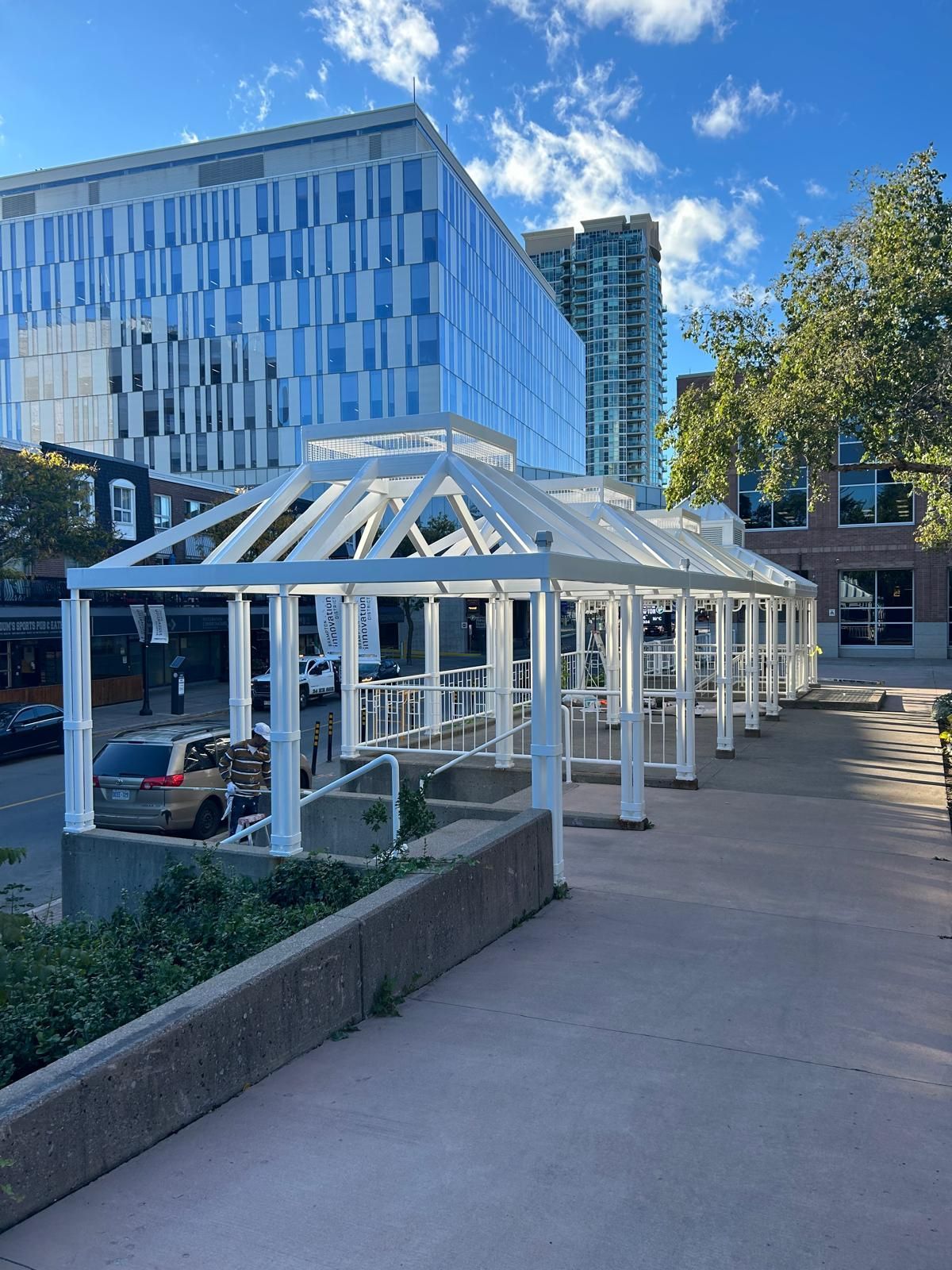 A row of white covered walkways in front of a building.