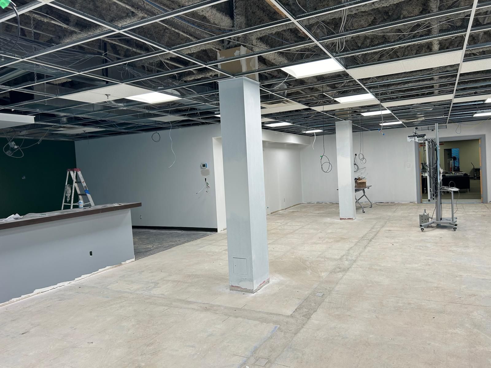 A large empty room with columns and a ladder.
