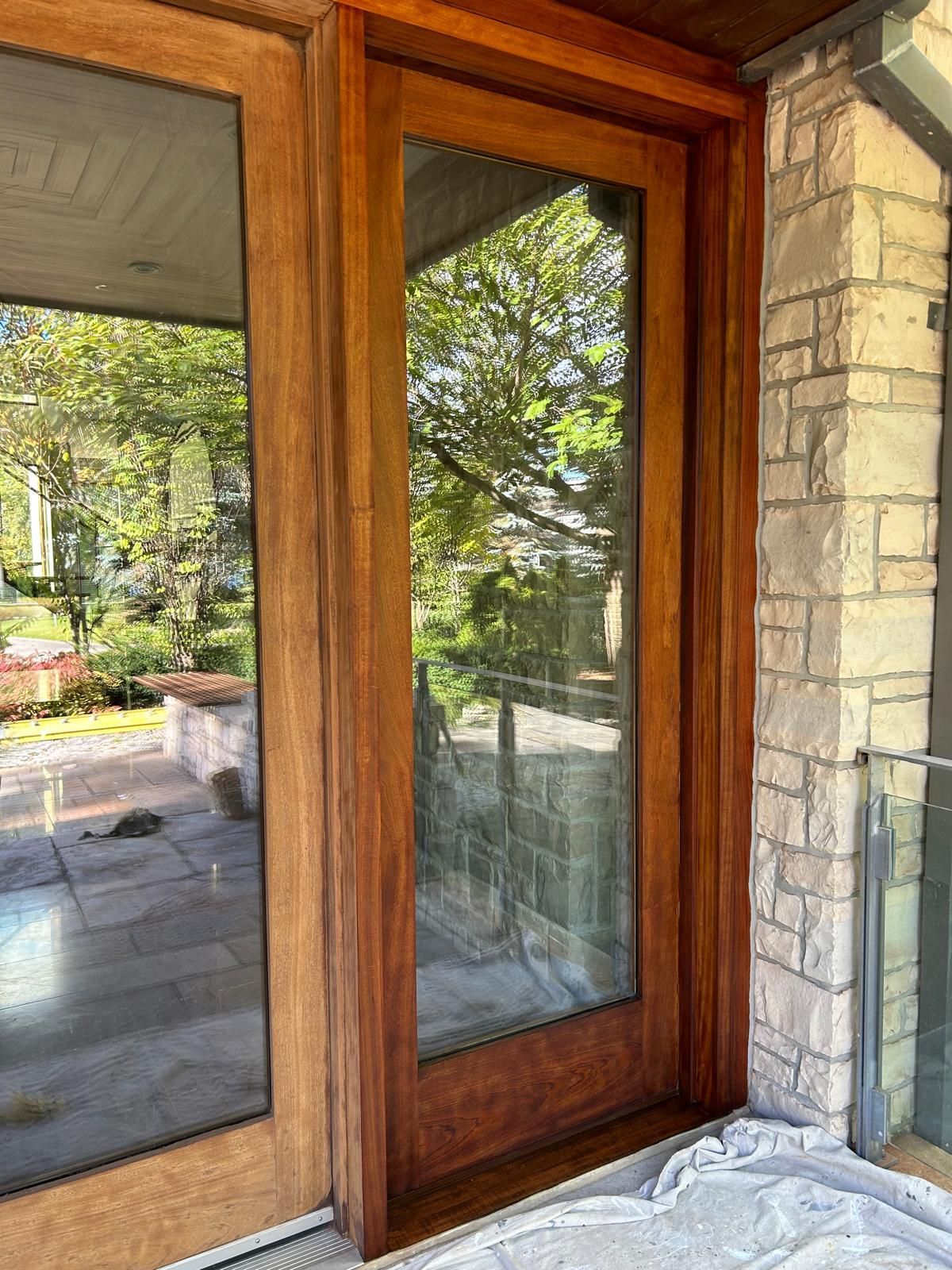 A wooden door with a glass window on a brick wall.