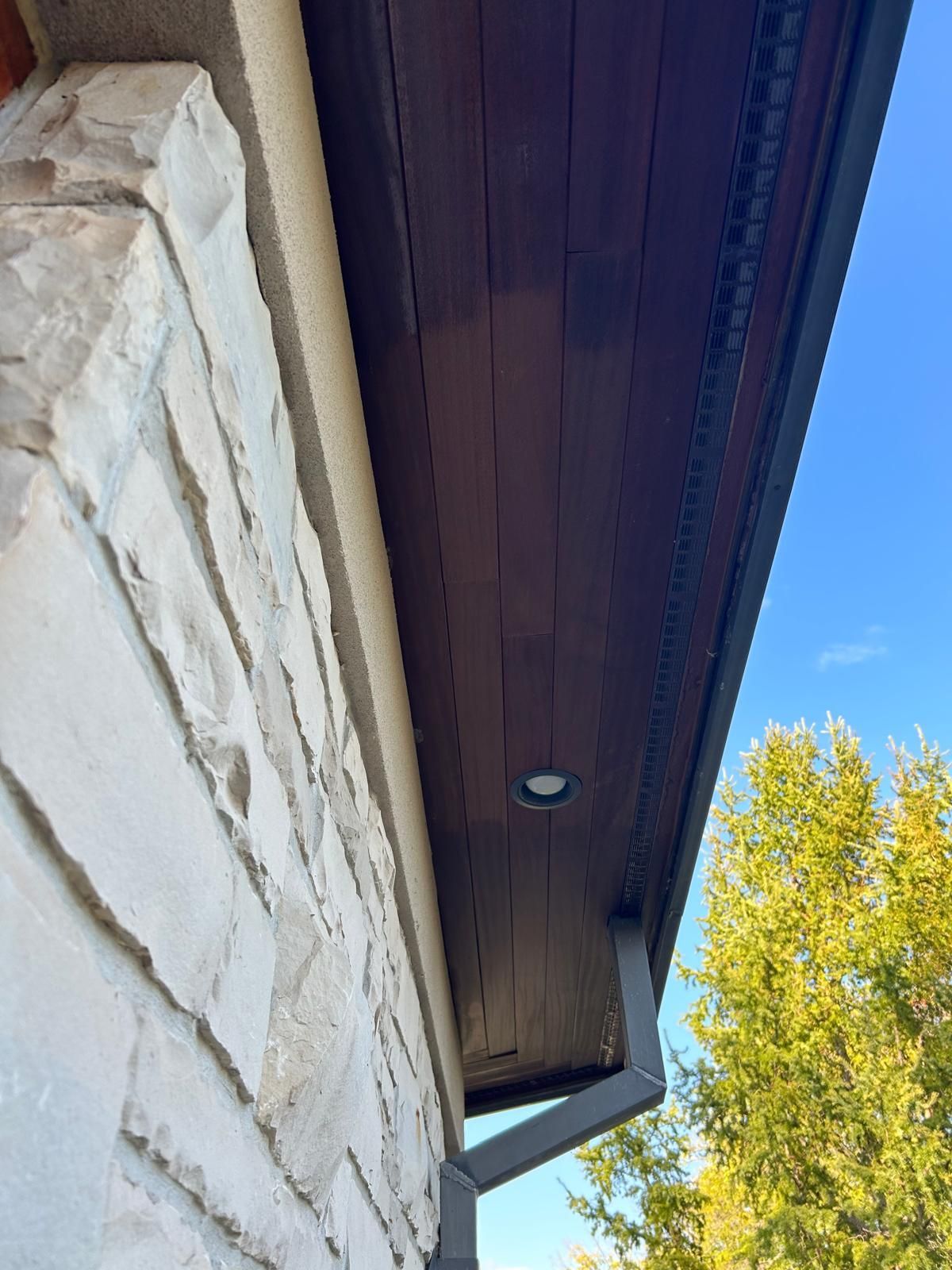 A brick building with a wooden ceiling and a gutter.