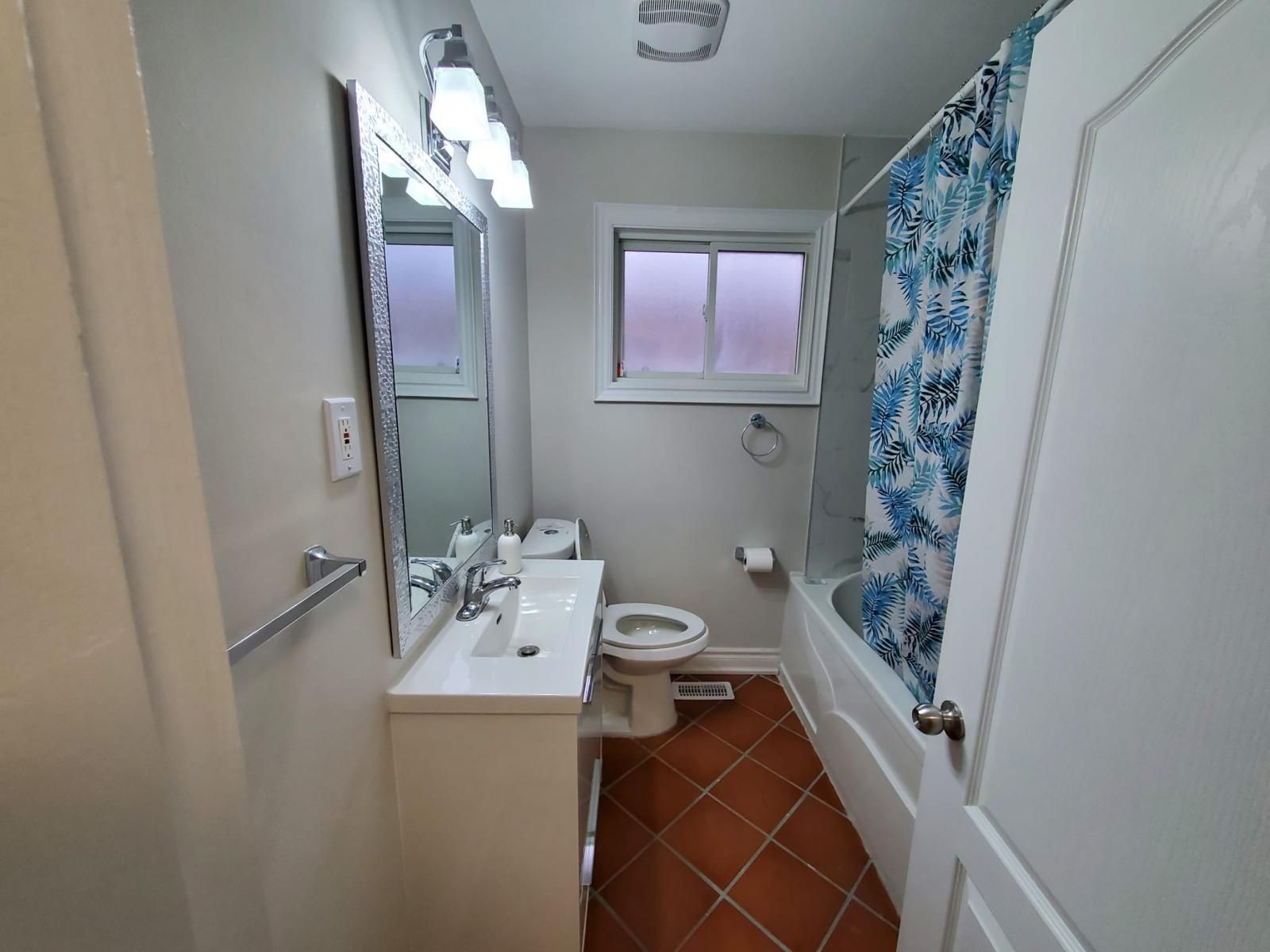 A bathroom with a toilet , sink , and bathtub.