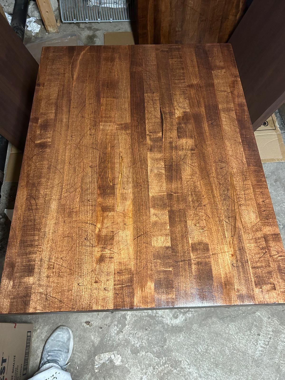 A person is standing on top of a wooden table.