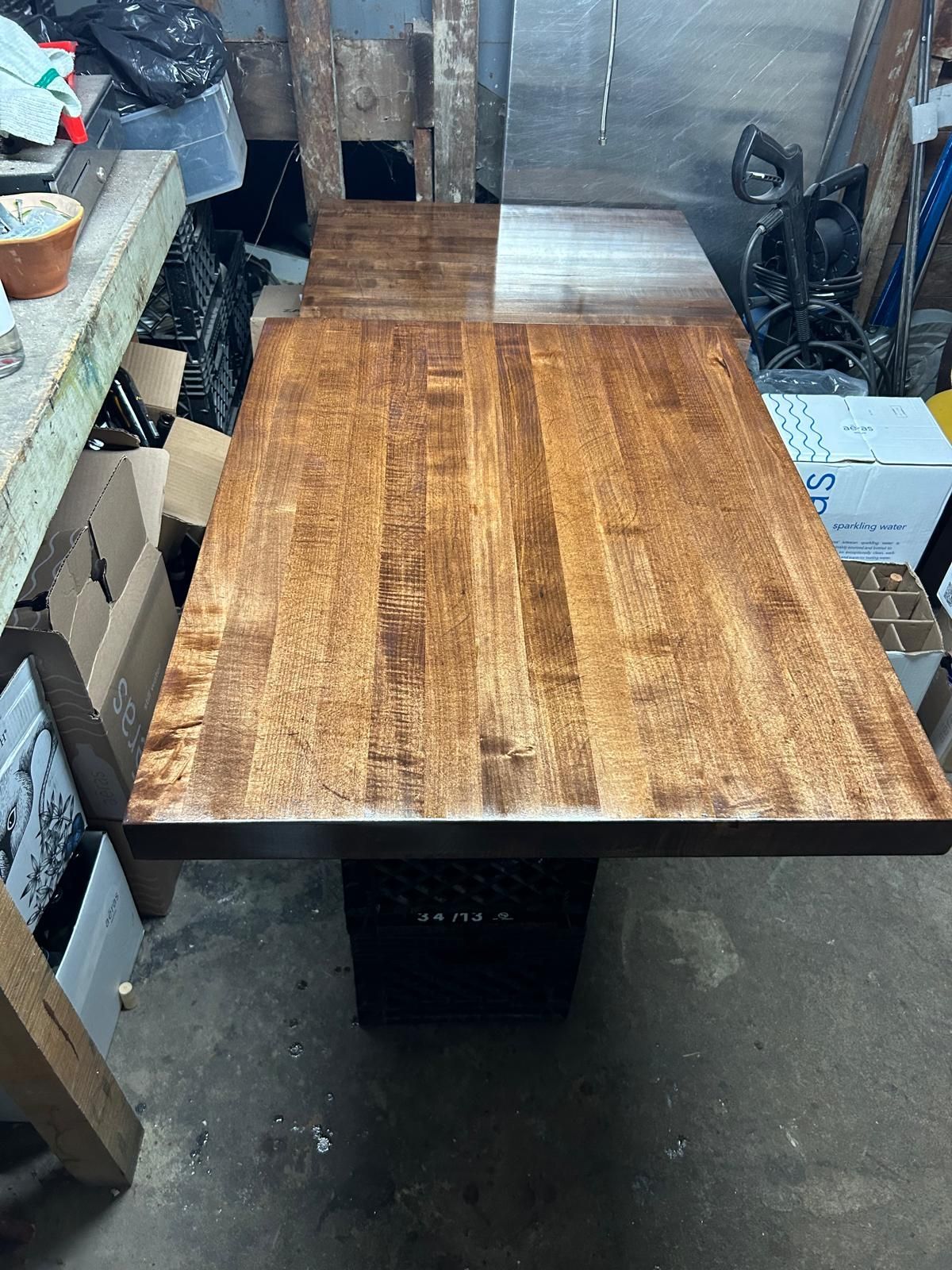 A wooden table is sitting on top of a concrete floor in a garage.