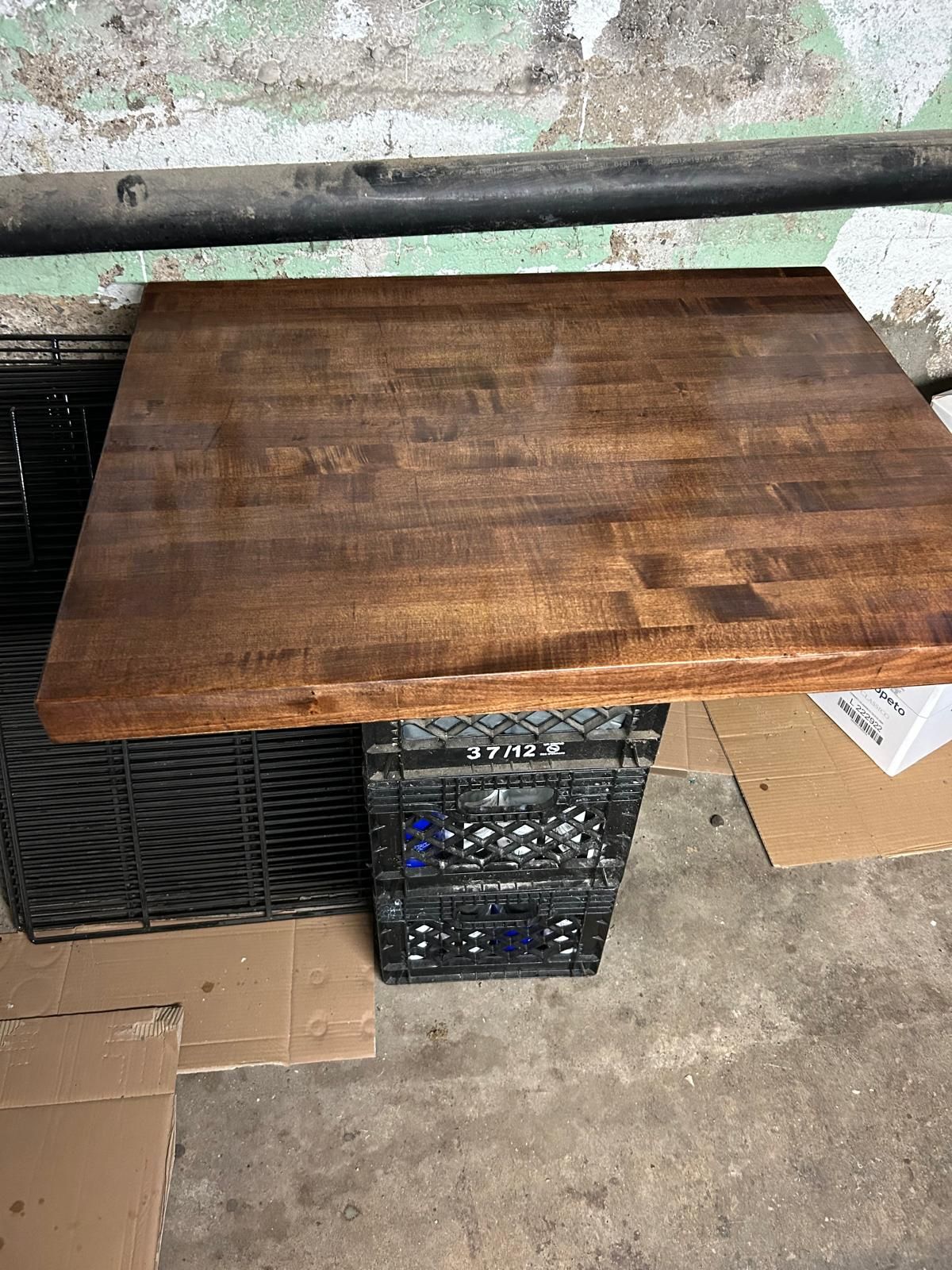 A wooden table is sitting on top of a pile of crates.