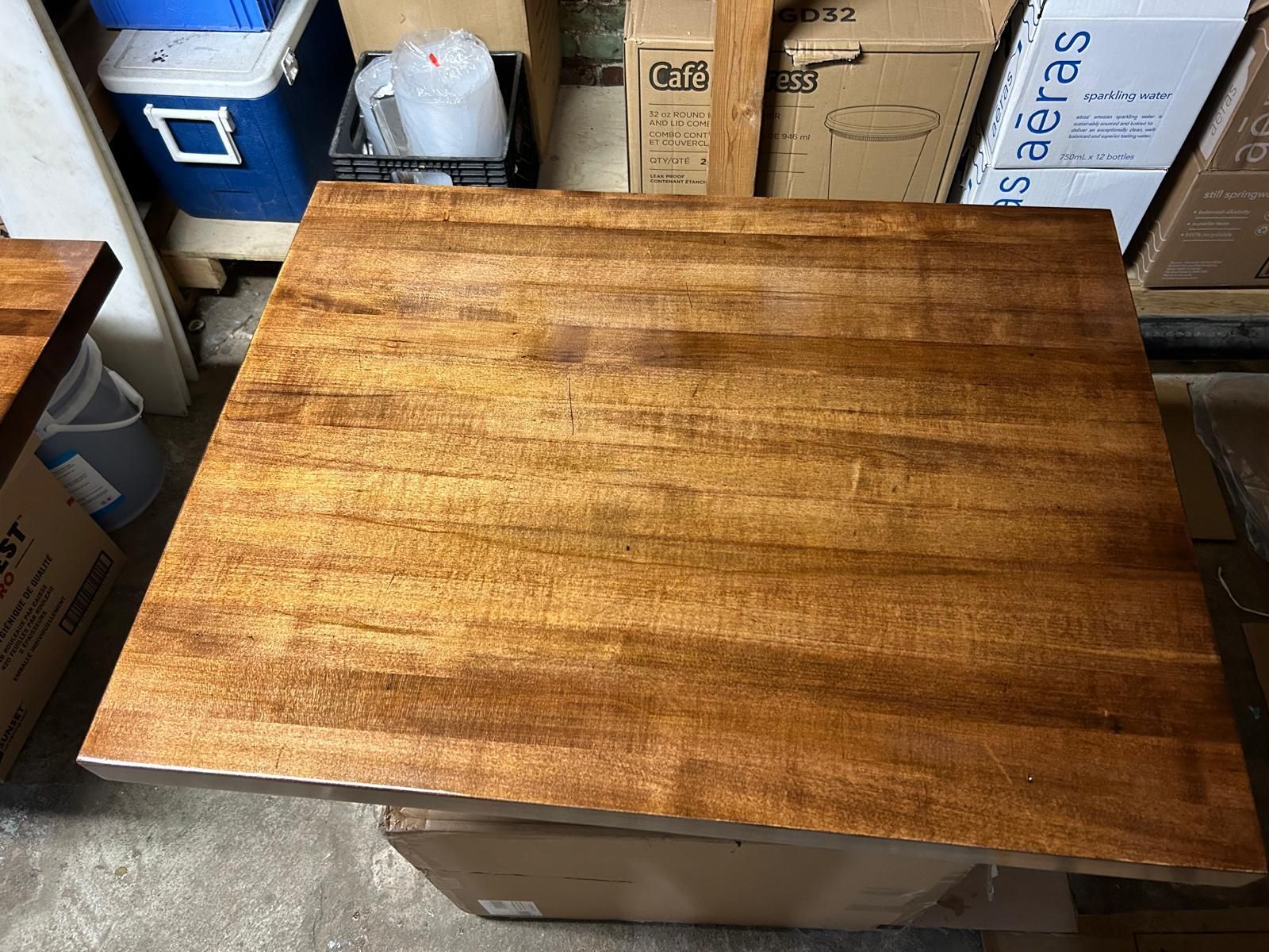 A wooden table is sitting on top of a cardboard box in a warehouse.